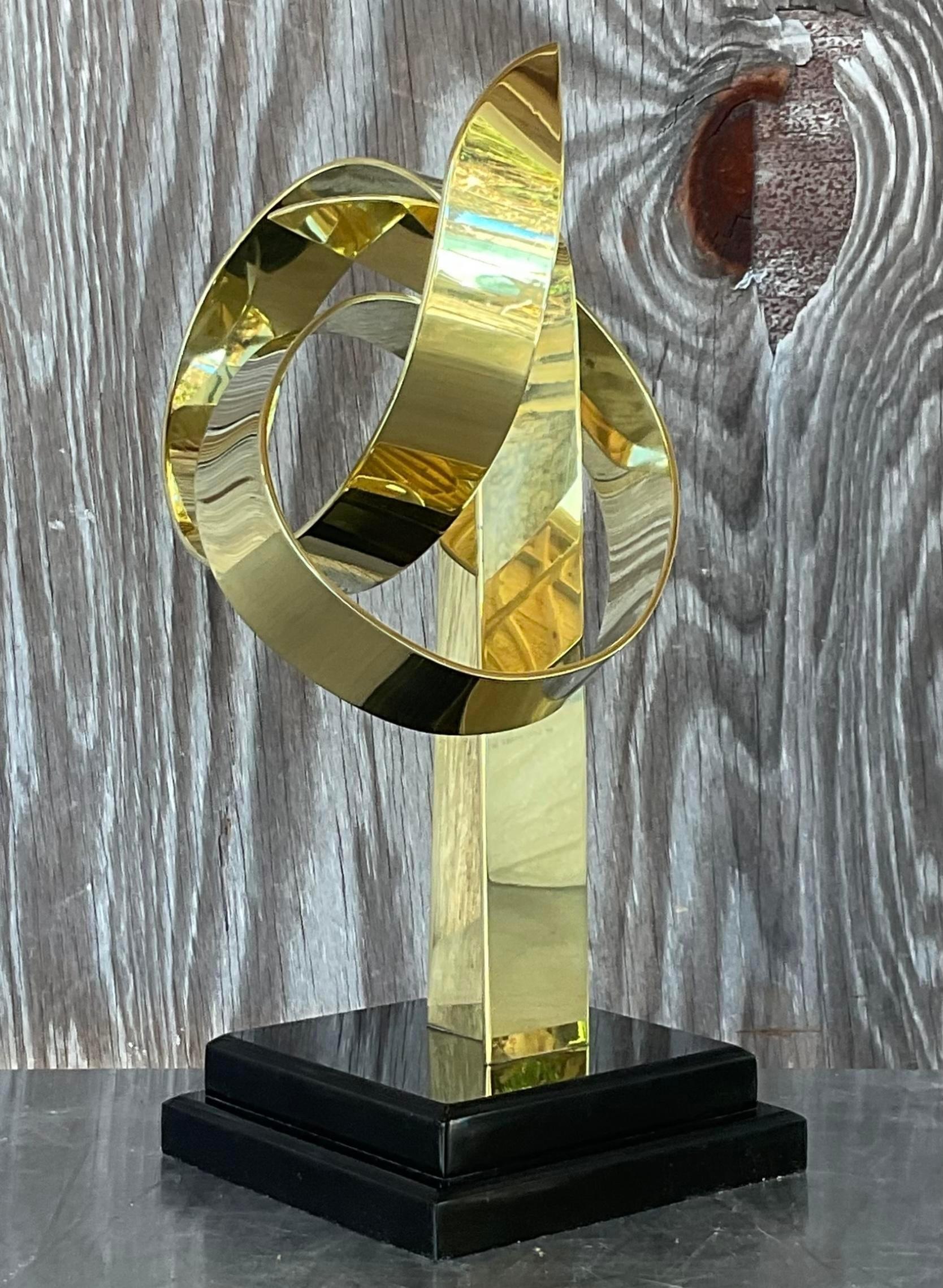 Echi d'ottone: La scultura vintage in ottone Van Teal Looping è un'accattivante testimonianza della creatività americana. Con le sue linee eleganti e il suo design senza tempo, incanala lo spirito del modernismo di metà secolo infondendo