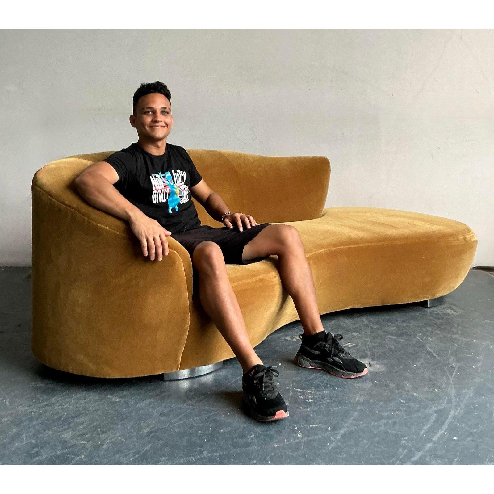 Inspirado en el diseño atemporal de Vladimir Kagan, este sofá serpentina vintage es una pieza impresionante que combina una lujosa tapicería de terciopelo con una forma orgánicamente fluida. El cálido tejido de terciopelo mostaza invita tanto a la