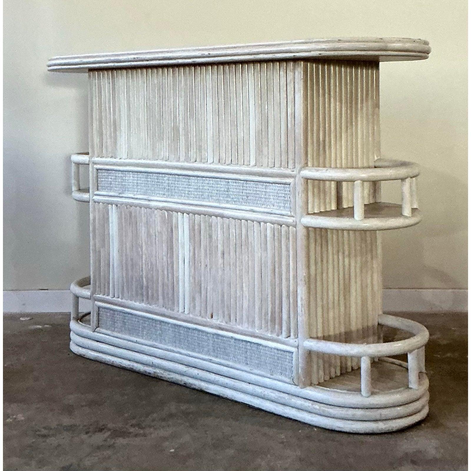 Este elegante bar seco vintage capta la estética de complejo turístico chic popularizada en los años 70, presentando una refinada visión del diseño tropical. Construida con robustos juncos de ratán y caña envuelta, la estructura presenta un