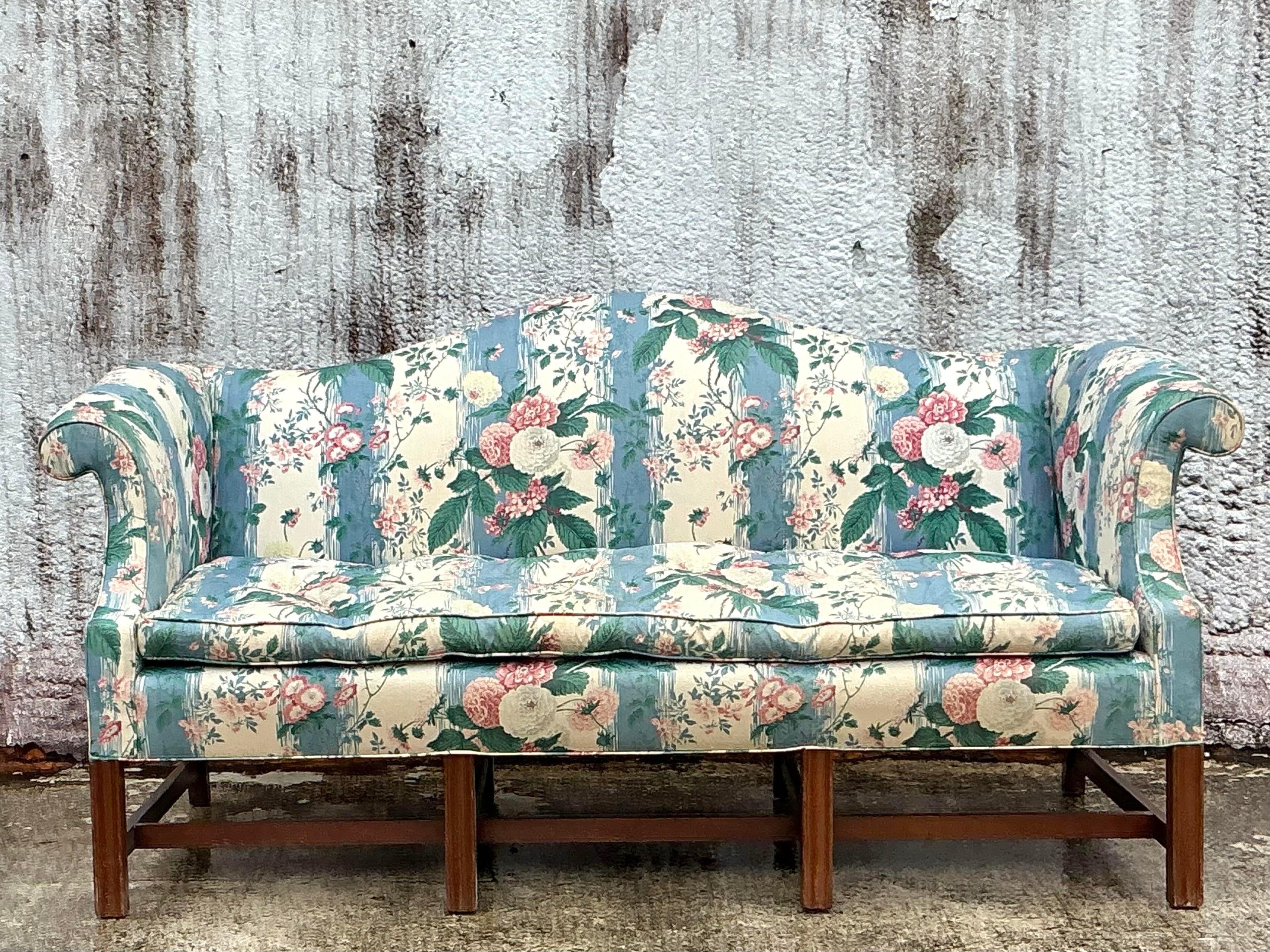 Make a bold statement with this Vintage Boho Waxed Chintz Camelback Sofa. Featuring the classic elegance of a camelback silhouette, this sofa is wrapped in vibrant, waxed chintz fabric that brings a touch of bohemian flair. The glossy finish