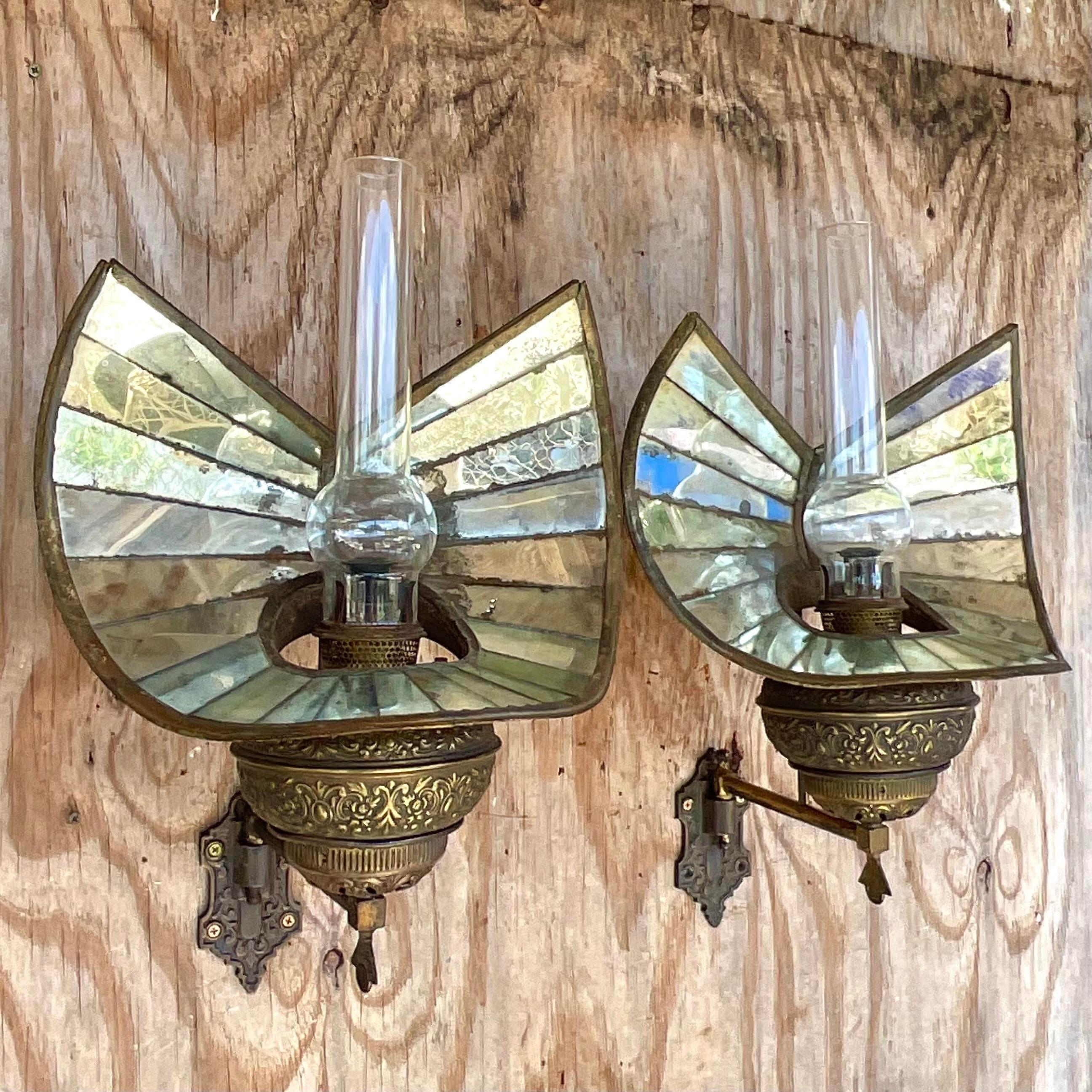 An exceptional pair of vintage Boho gas wall lanterns. Made by the iconic Wheeler Reflector Co. and tagged on the back. Gorgeous stacked mirror screen with glass chimneys and brass body. Acquired from a Palm Beach estate. 