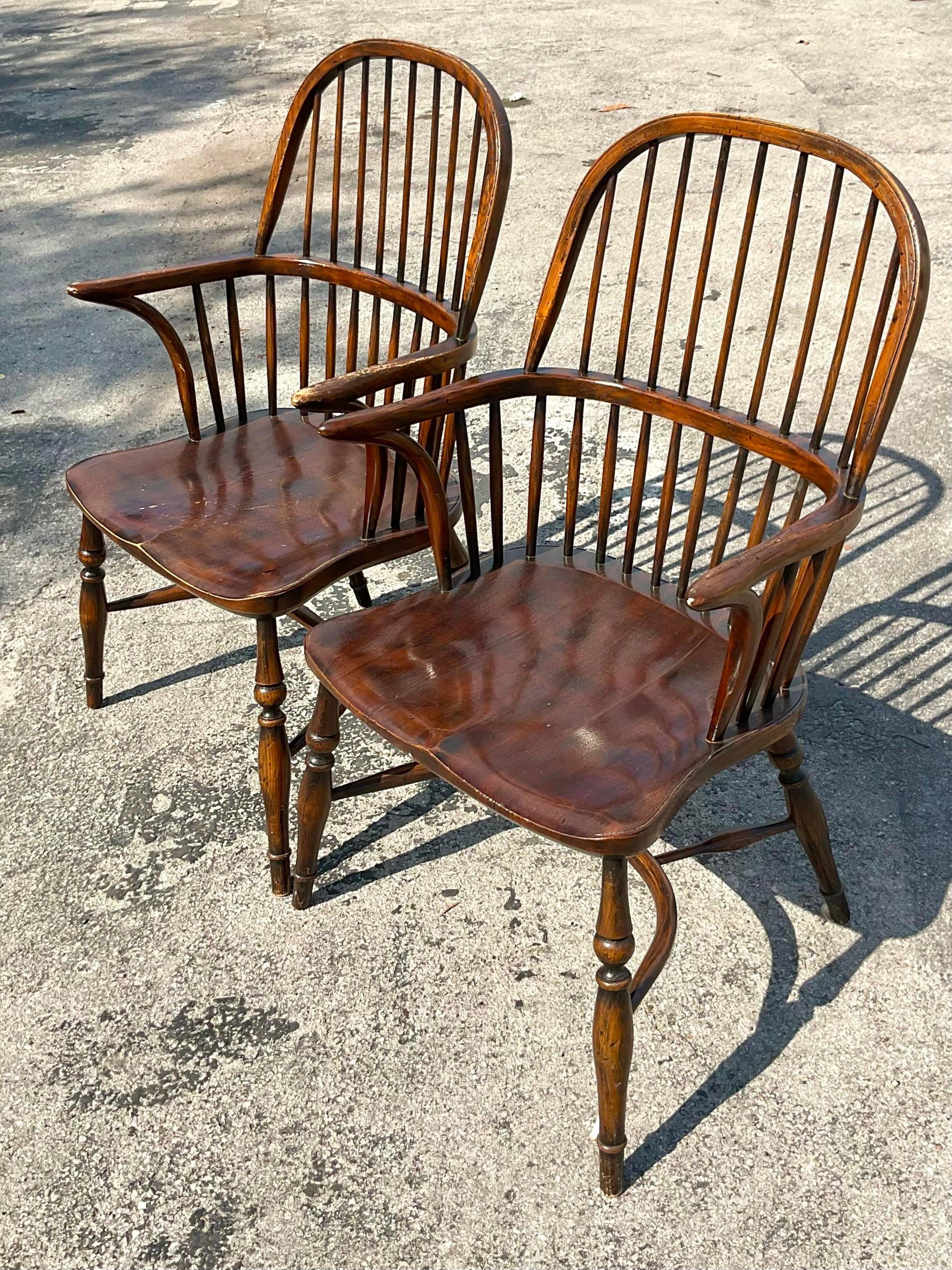 A fabulous pair of vintage boho arm chairs. A chic high back Windsor style with beautiful wood grain detail. Acquired from a Palm Beach estate.