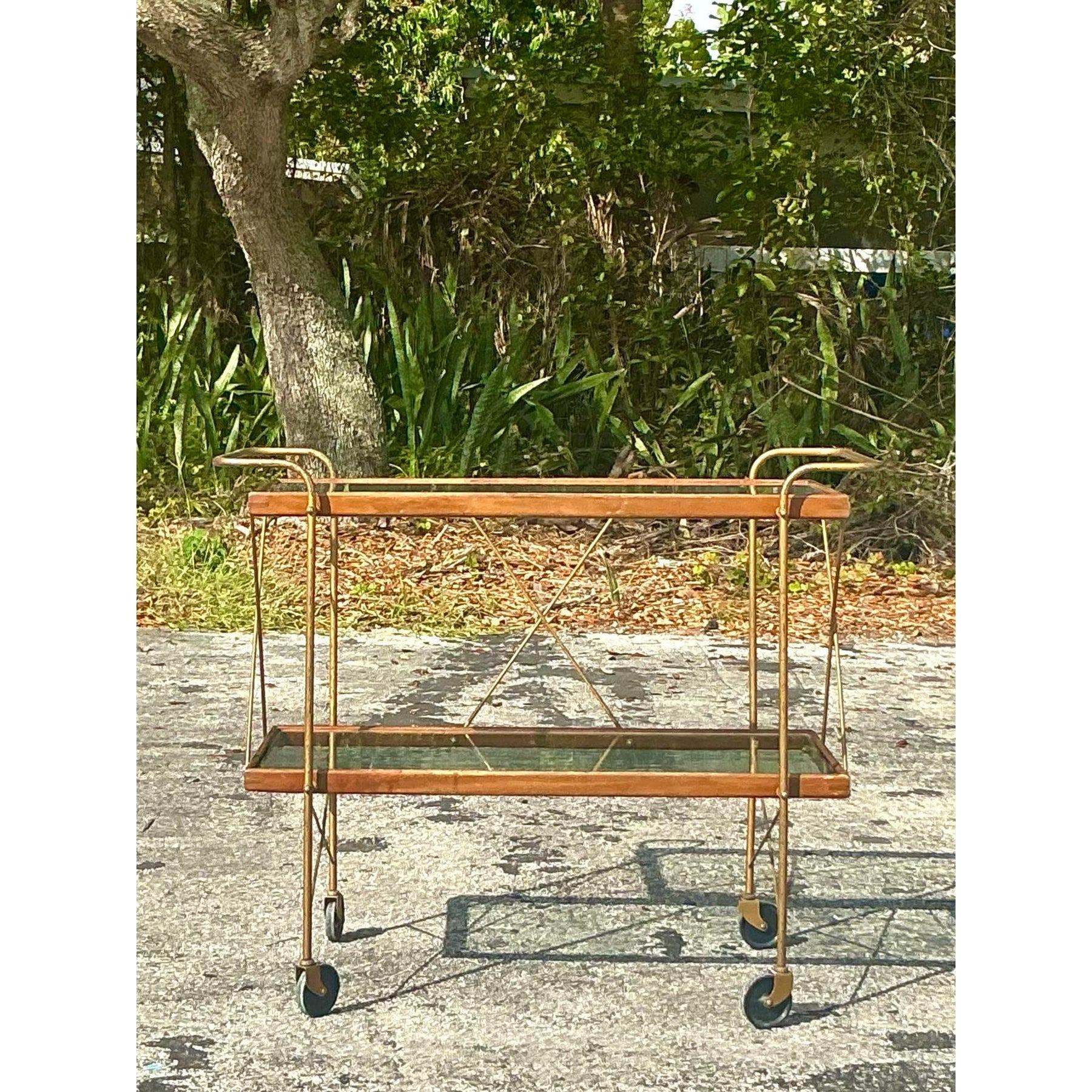 Recevez avec style grâce à ce superbe chariot de bar boho vintage, un mélange parfait de fonctionnalité et de charme intemporel. Doté d'un cadre en bois épuré et d'accents métalliques couleur laiton, ce chariot à deux niveaux est conçu avec des