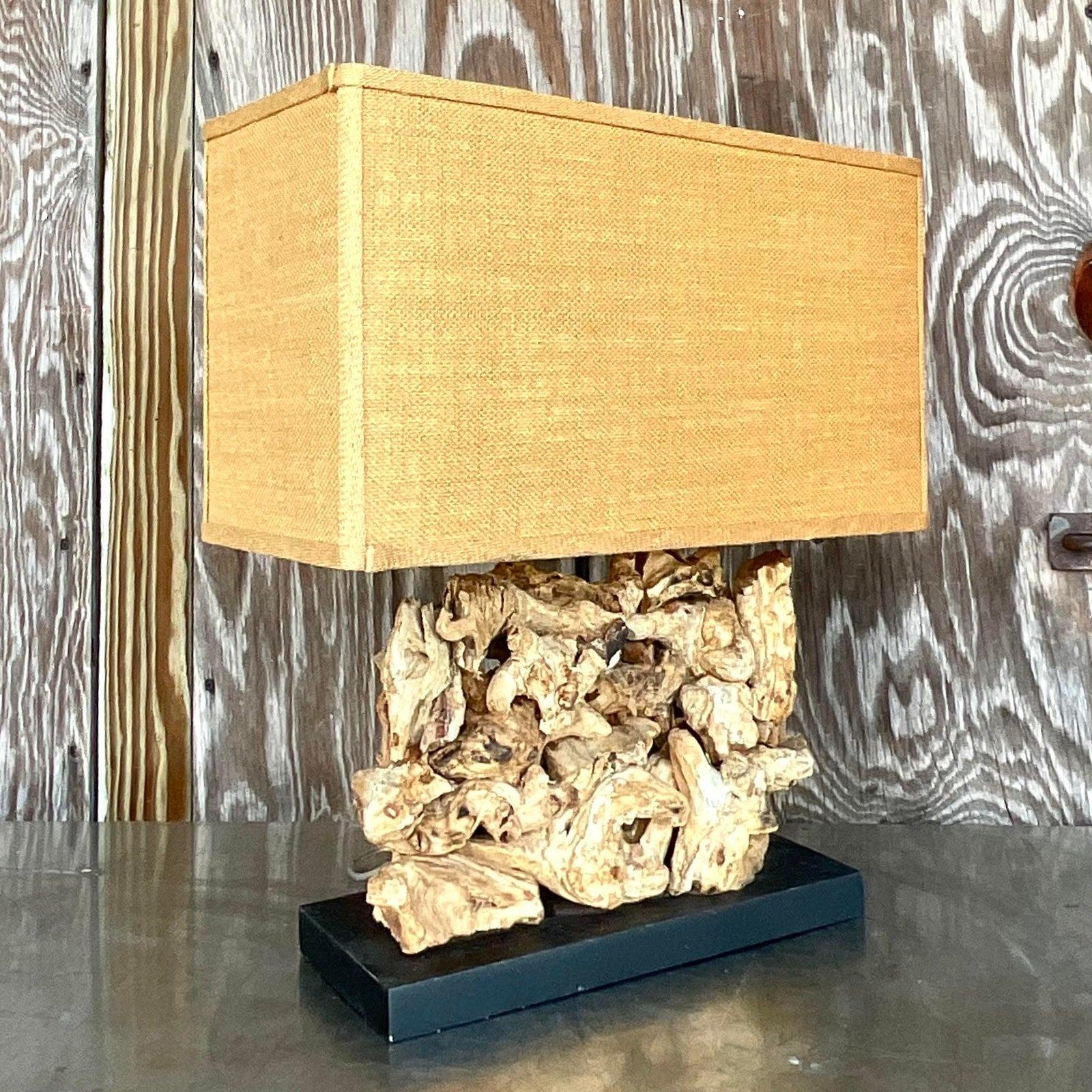 A fabulous vintage Boho table lamp. A chic block of wood knots with a coordinating burlap shade. Acquired from a Palm Beach estate.