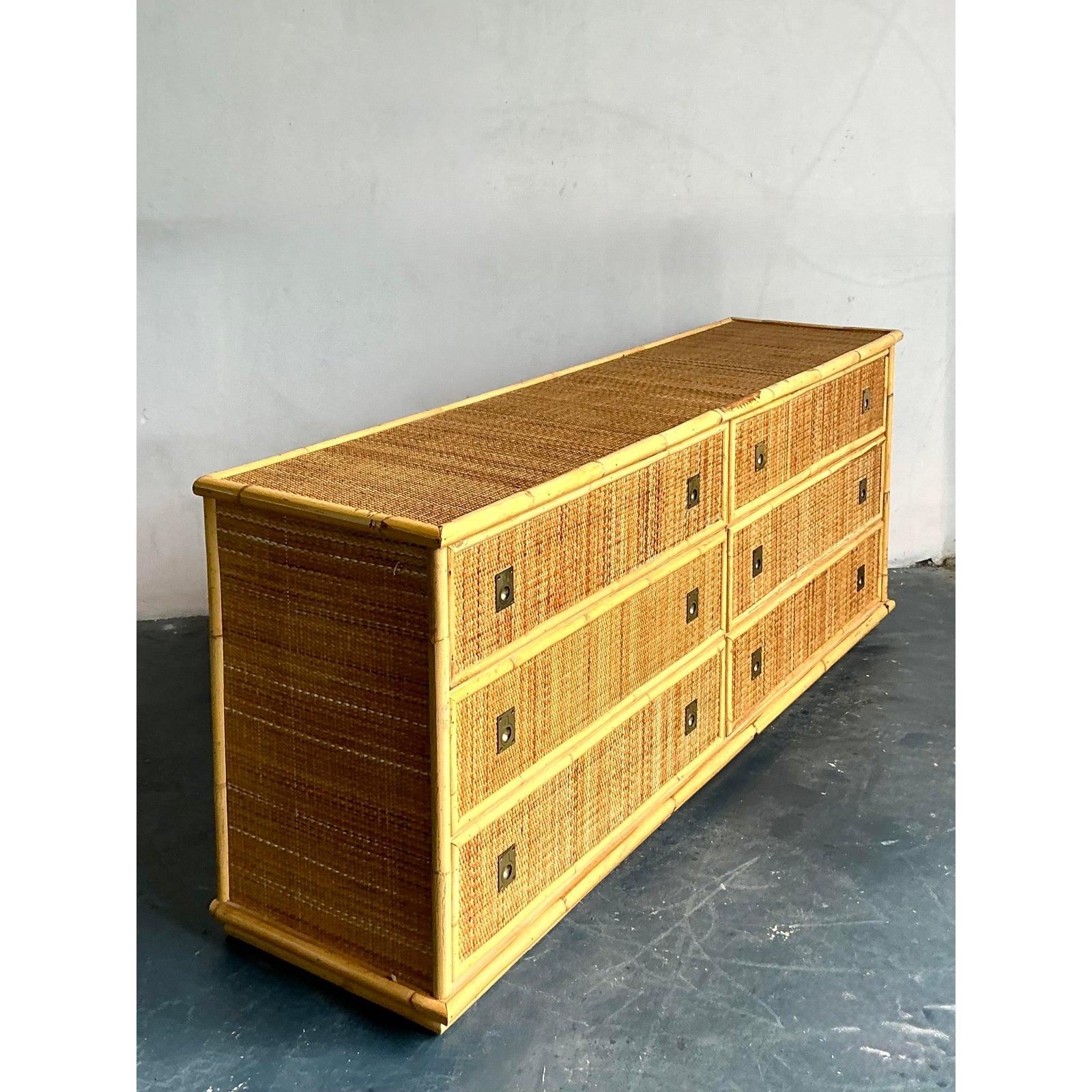 Eleg, l'élégance organique de cette superbe commode vintage de style campagne. Rappelant les iconiques designs italiens de Dal Vera, cette pièce témoigne du savoir-faire sophistiqué des années 1970. Habillée de rotin naturel tressé et d'un cadre en