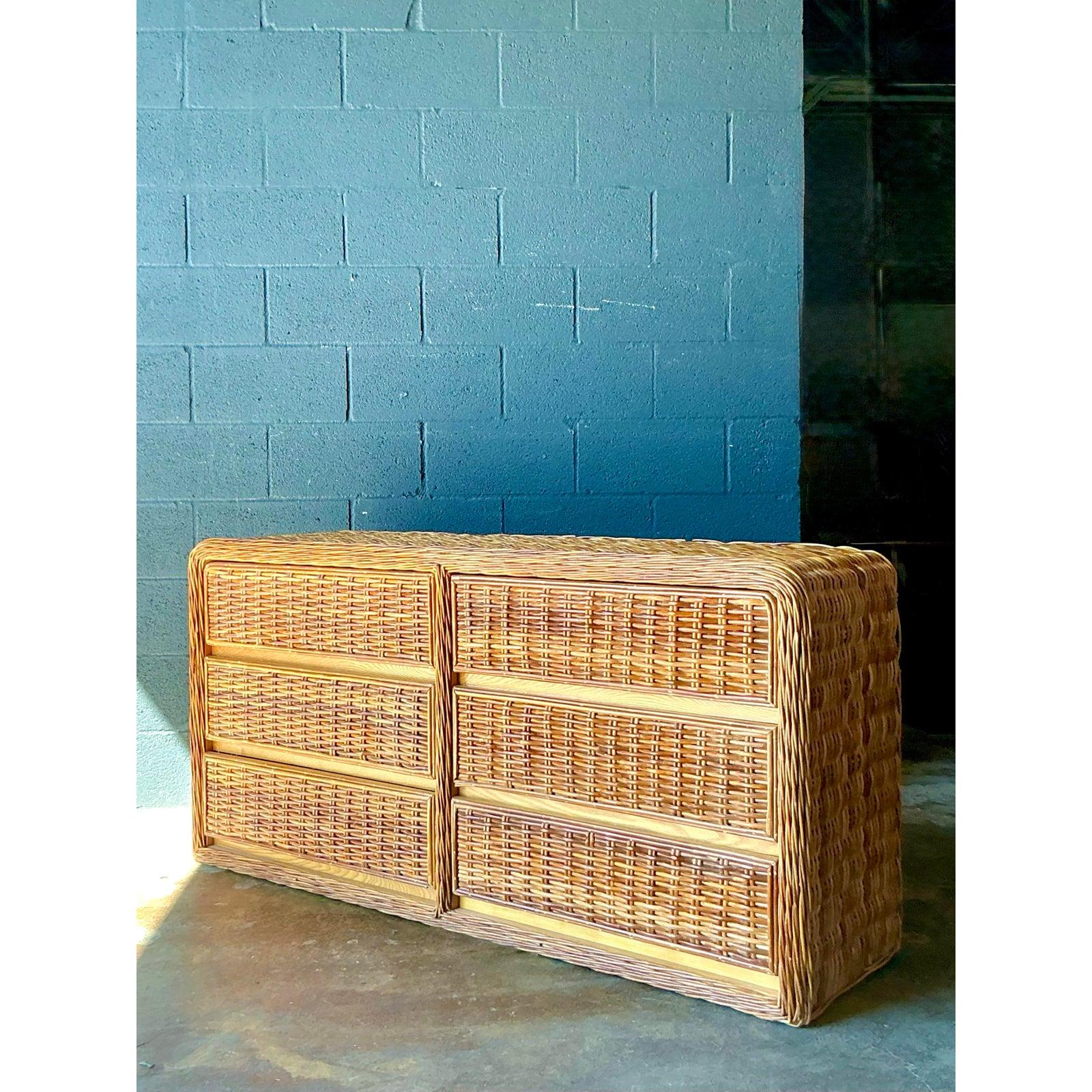 Cette remarquable commode vintage est un exemple exceptionnel de l'esthétique bohème tropicale haut de gamme popularisée dans le style des stations balnéaires des années 1970 et 1980. Entièrement fabriquée en rotin et en canne finement tressés,