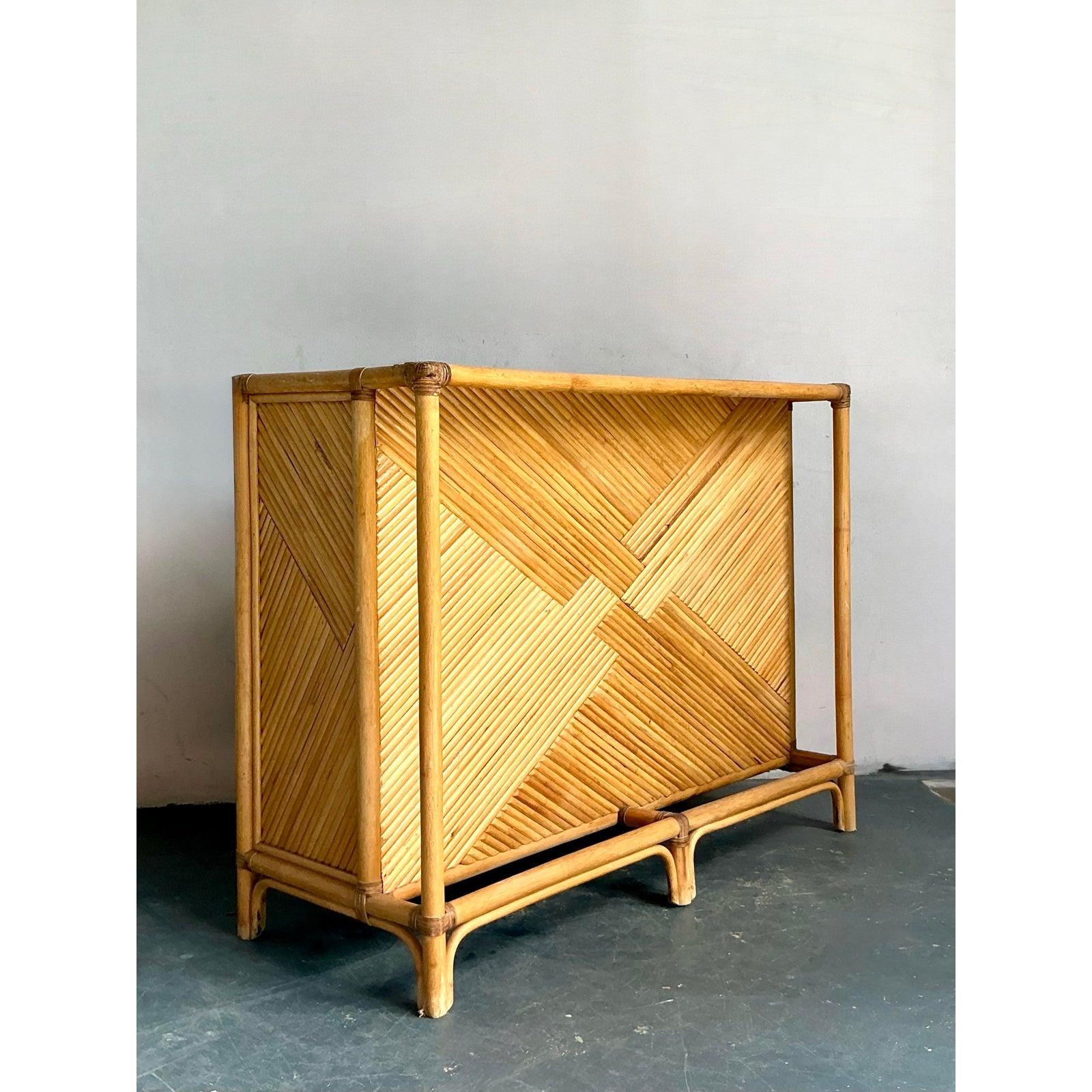 Infuse your home with a relaxed, resort-style vibe with this captivating vintage woven rattan dry bar. This piece beautifully embodies a blend of Boho chic and tropical aesthetics, featuring intricately woven rattan panels that create a dynamic,