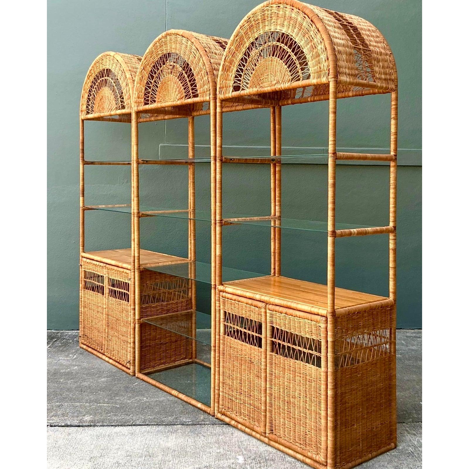 Crea un impresionante punto focal en tu hogar con este monumental mueble alto de ratán vintage. Este impresionante sistema modular presenta tres elevadas torres, cada una coronada por un elegante arco arquitectónico adornado con intrincados detalles