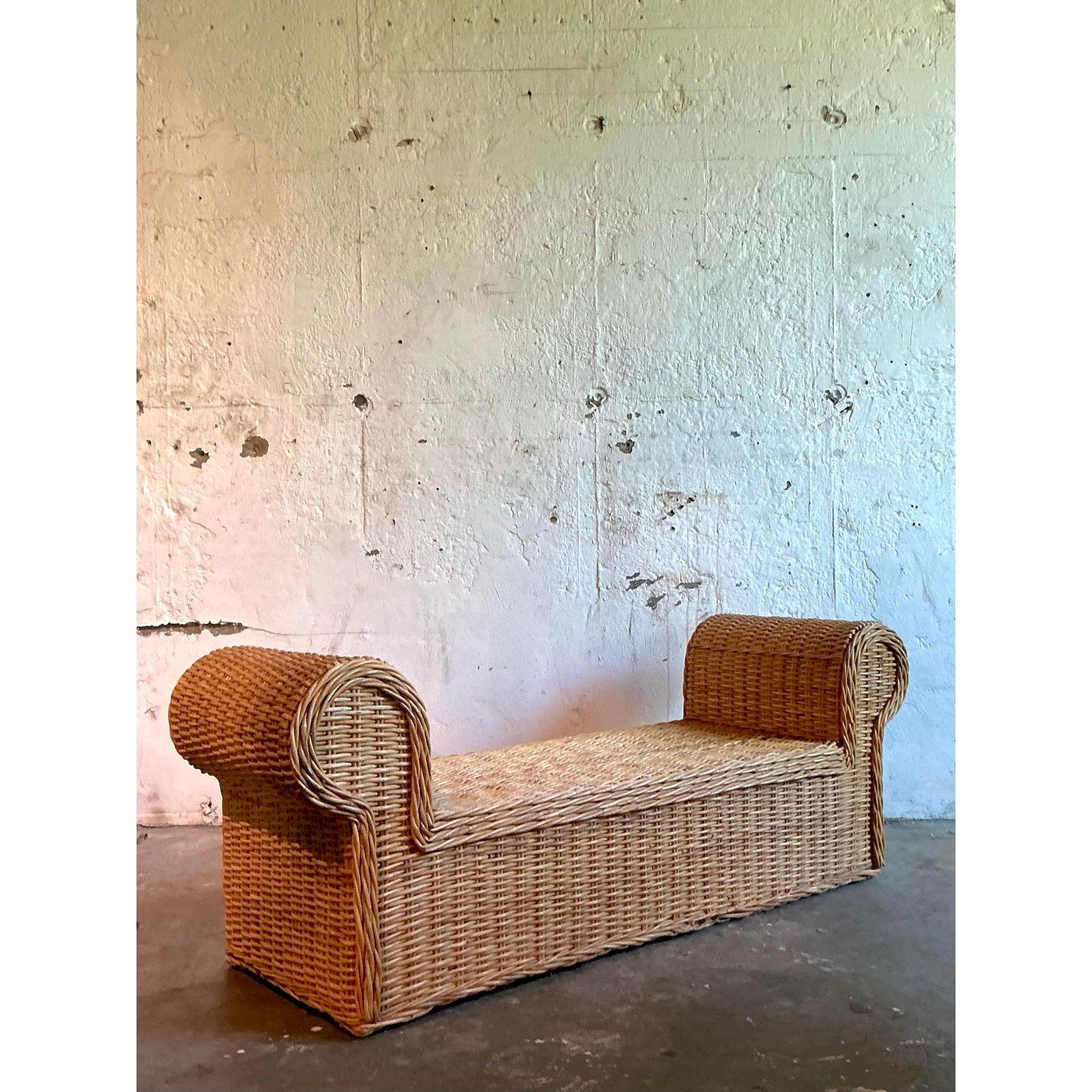 Infunde a tu espacio la sofisticación relajada de este banco vintage de ratán tejido. Esta pieza, maravillosamente hecha a mano, celebra el atractivo atemporal de los materiales naturales, con un asiento de tejido tupido y brazos enrollados