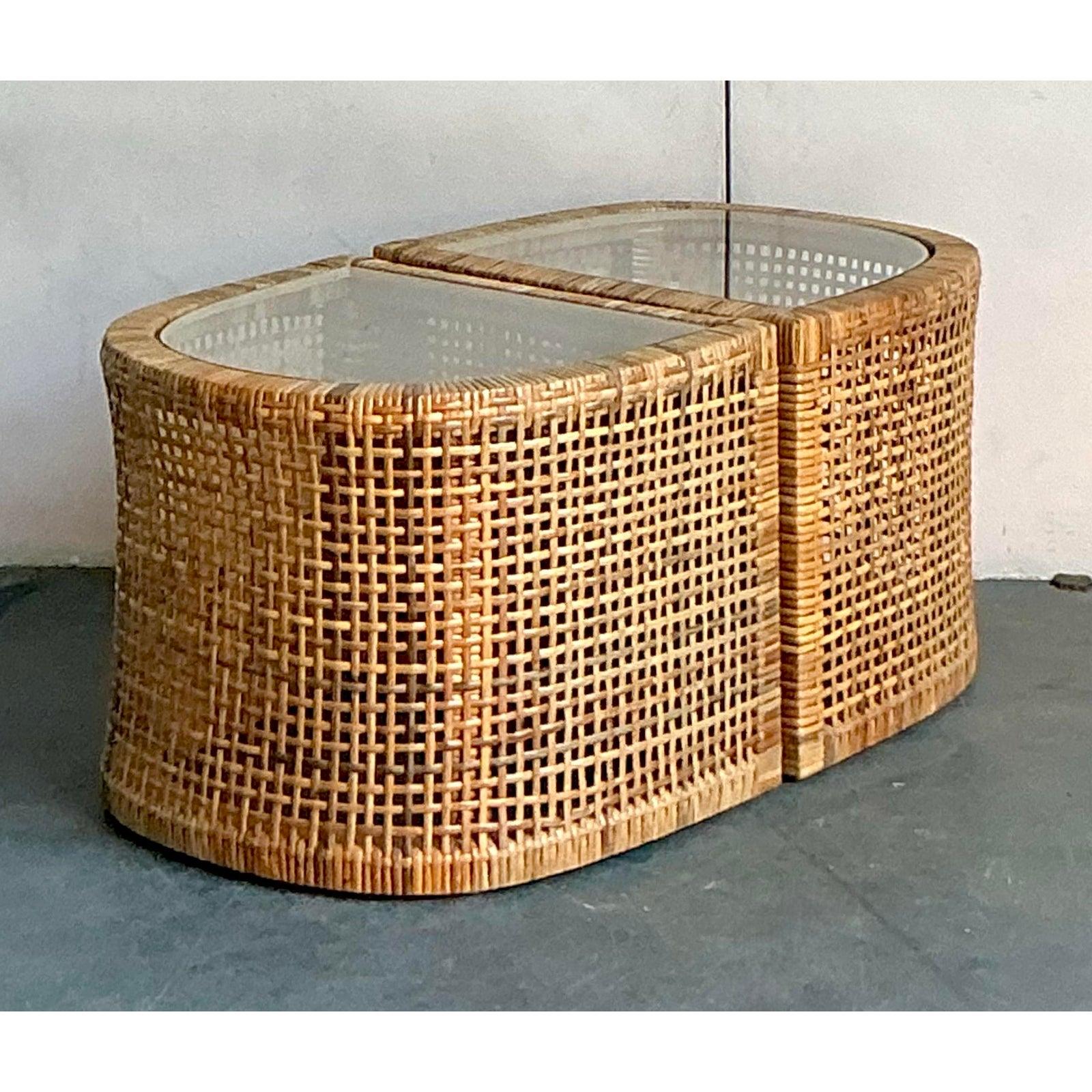 Presenting a captivating set of two vintage side tables, masterfully crafted from woven rattan, embodying the free-spirited elegance of Boho Chic design. These charming tables, likely from the mid to late 20th century, showcase exquisite