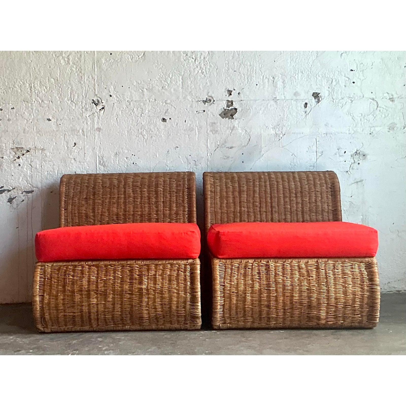 Infuse your space with the effortless style of bohemian coastal living with this captivating pair of vintage woven rattan slipper chairs. Expertly crafted, each chair showcases the timeless art of wicker weaving, bringing a rich, organic texture and
