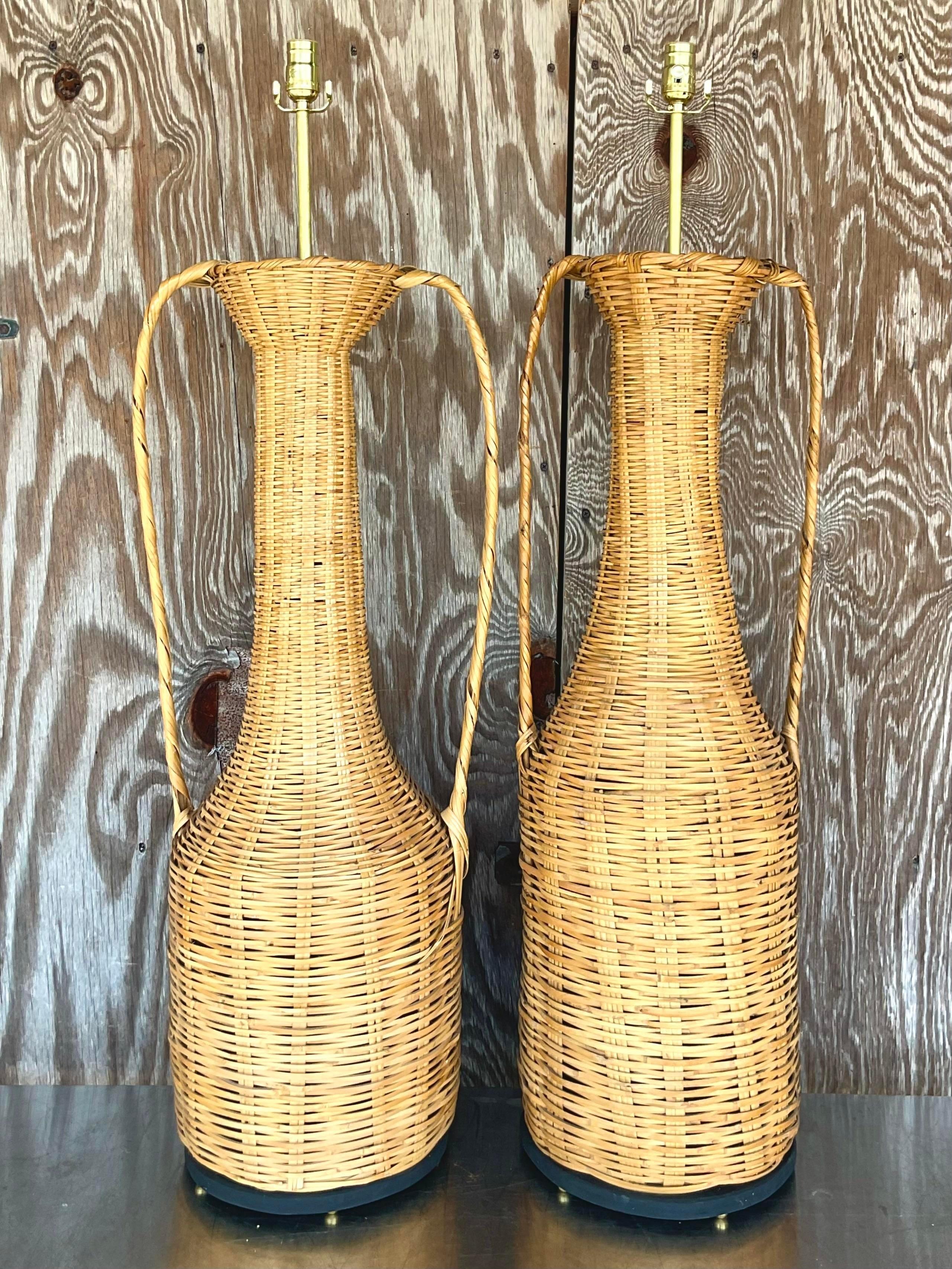 A fantastic set of vintage Coastal table lamps. A beautiful woven rattan on raised plinths. Mismatched handles make these lamps something special. Fully restored with all new wiring and hardware. Acquired from a Palm Beach estate.

Smaller lamp