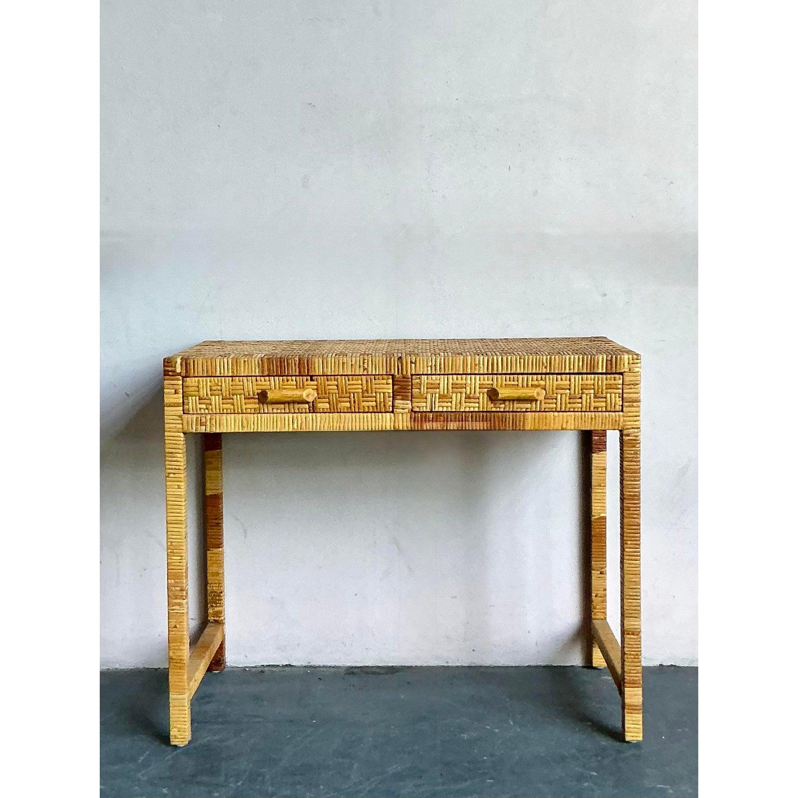 Dieser charmante Vintage-Konsolentisch, der hauptsächlich aus kunstvoll geflochtenem Rattan und schlankem Bleistiftrohr besteht, verkörpert die natürliche, taktile Ästhetik des Boho-Chic und des tropischen Modernismus. Die Oberflächen sind