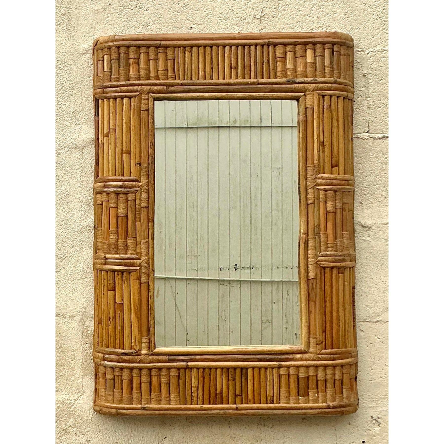 Questo splendido specchio vintage in bambù emana un fascino bohémien senza sforzo grazie alla sua intricata cornice in bambù avvolto. La texture naturale e la calda finitura color miele lo rendono un pezzo d'accento perfetto per gli interni