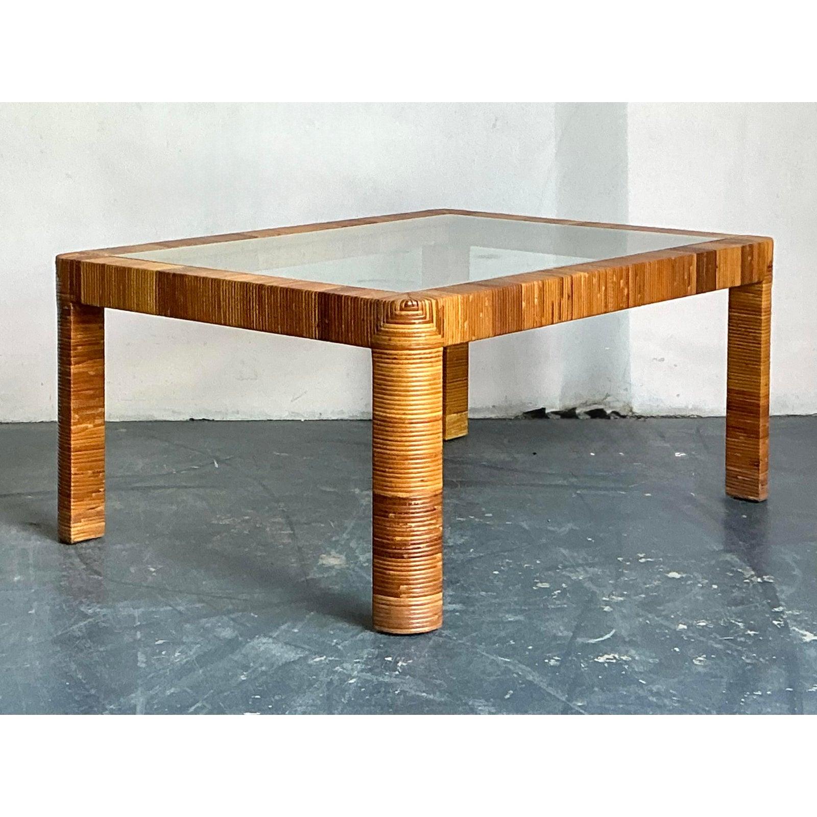 Esta excepcional mesa de centro muestra el sofisticado uso de materiales naturales popularizado por las casas de diseño de ratán de mediados de siglo, como Bielecky Brothers. La mesa presenta una silueta atrevida y rectilínea totalmente envuelta en