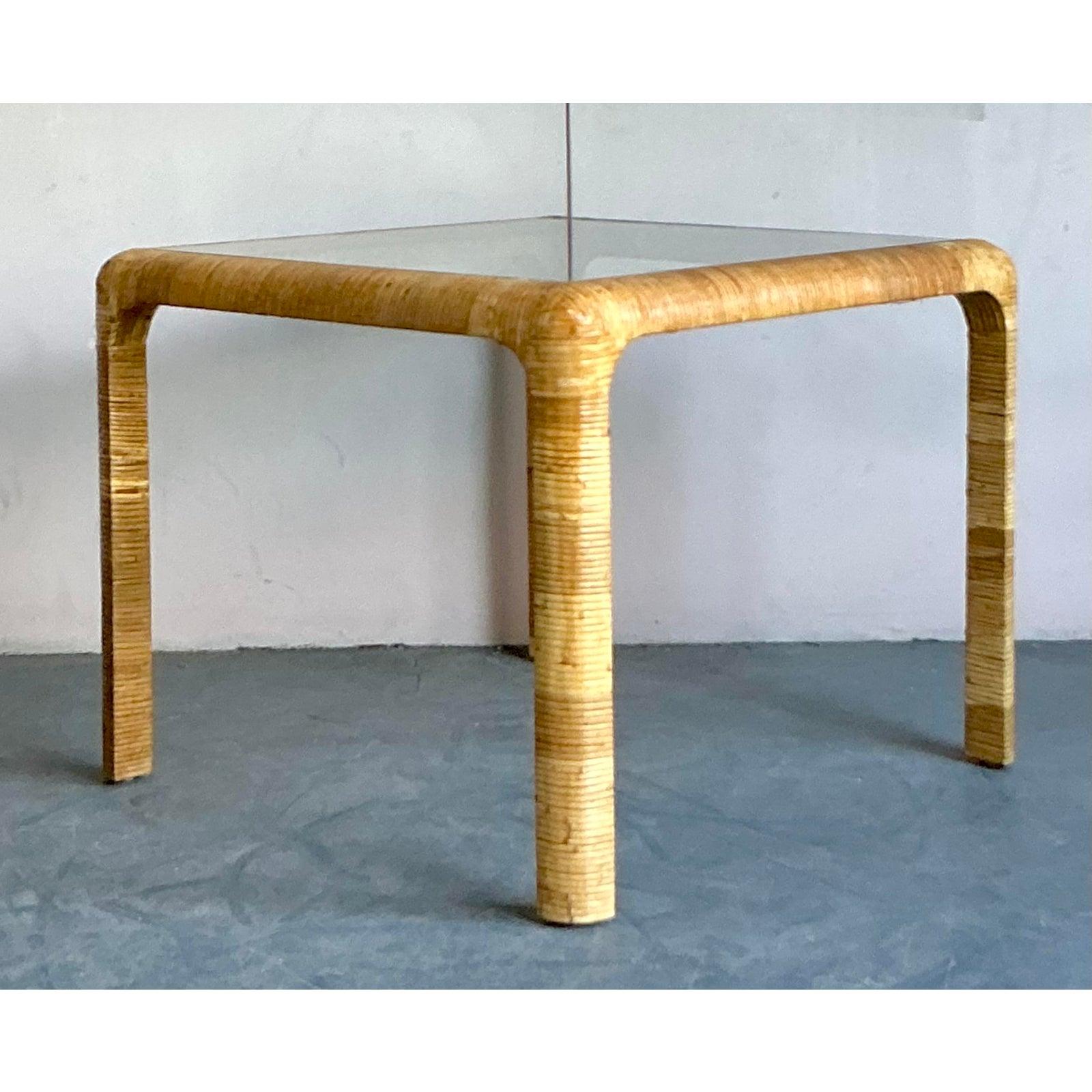 Una muestra magistral de diseño moderno orgánico, este conjunto de mesa de juego vintage es un impresionante ejemplo del arte del ratán hecho a mano. La mesa presenta una sólida base de pedestal de cuatro columnas, meticulosamente envuelta en ratán