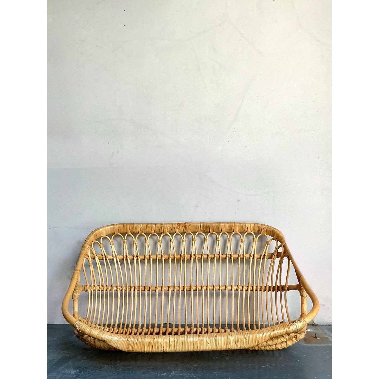 Discover the allure of this extraordinary vintage Boho wrapped rattan hanging bench, an iconic piece that effortlessly marries comfort with quintessential mid-century design. Expertly handcrafted from natural rattan, this bench features a gracefully