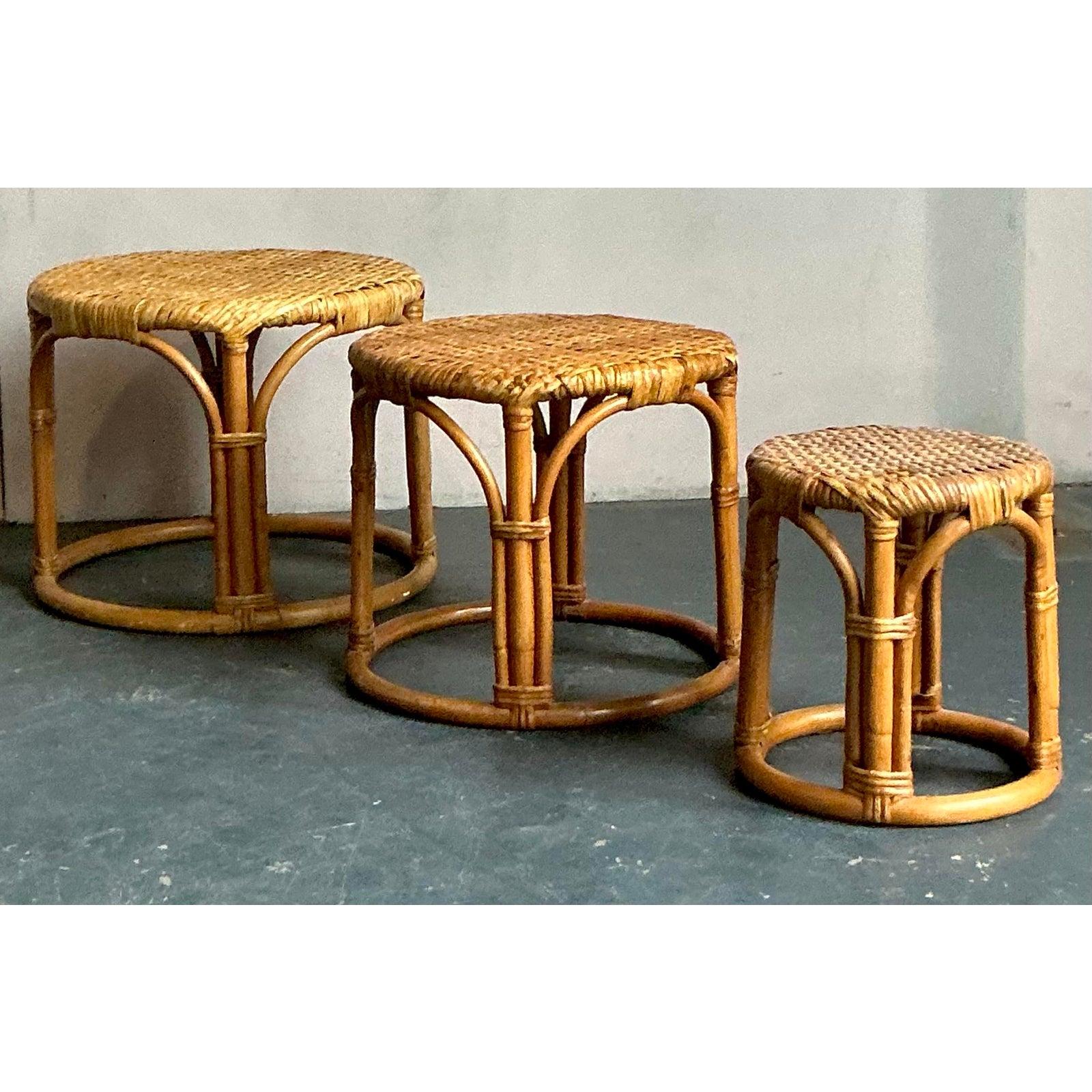 Eleva il tuo spazio abitativo con questo incantevole set di tre tavolini impilabili in rattan vintage avvolti da un'atmosfera rilassata ma sofisticata. Realizzati con una meticolosa attenzione ai dettagli, questi tavoli mostrano il fascino duraturo