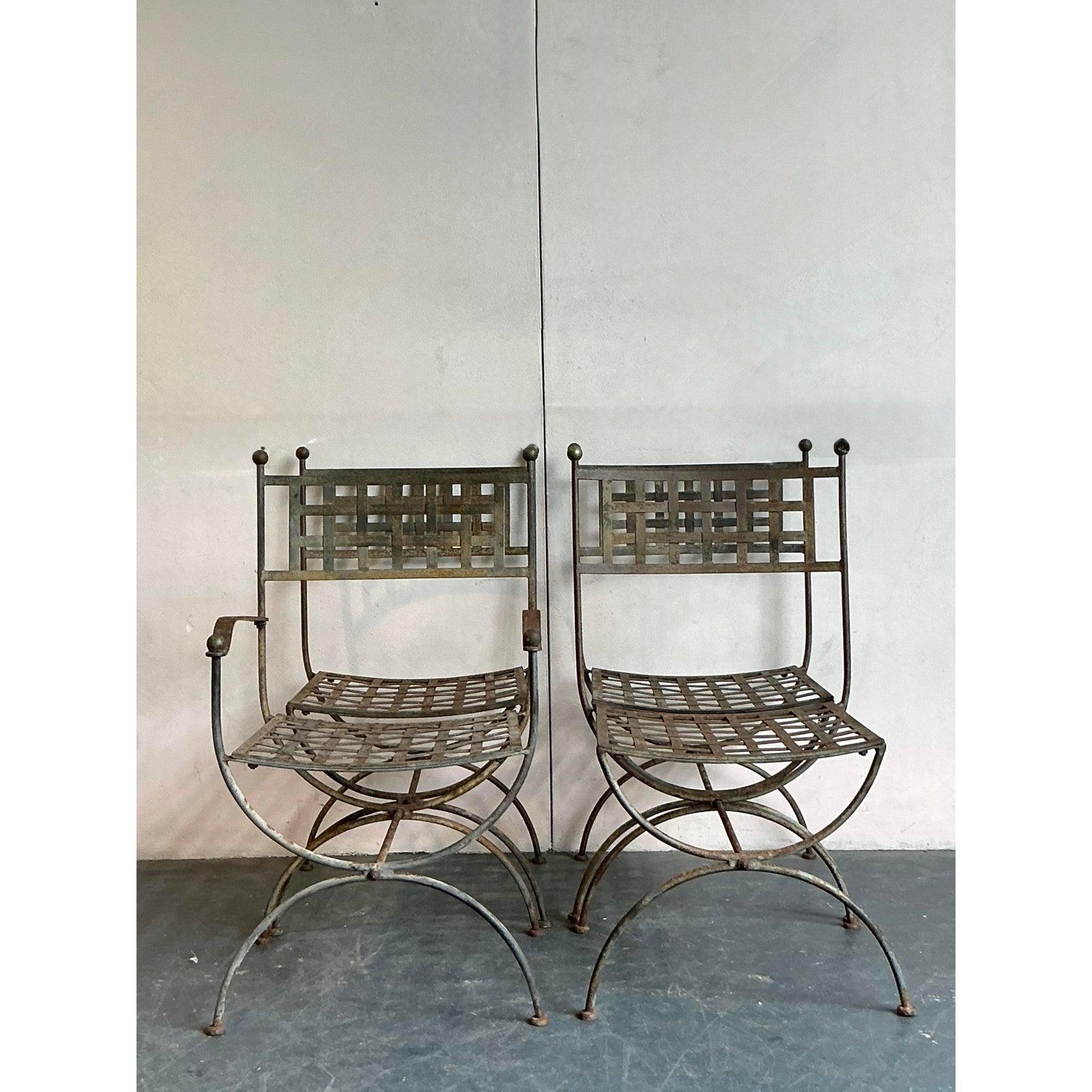 Presenting a remarkable set of four vintage dining chairs after the acclaimed Maurizio Tempestini, embodying a captivating blend of Greco-Roman influences and bohemian allure. Crafted from elegantly distressed wrought iron, these chairs feature a