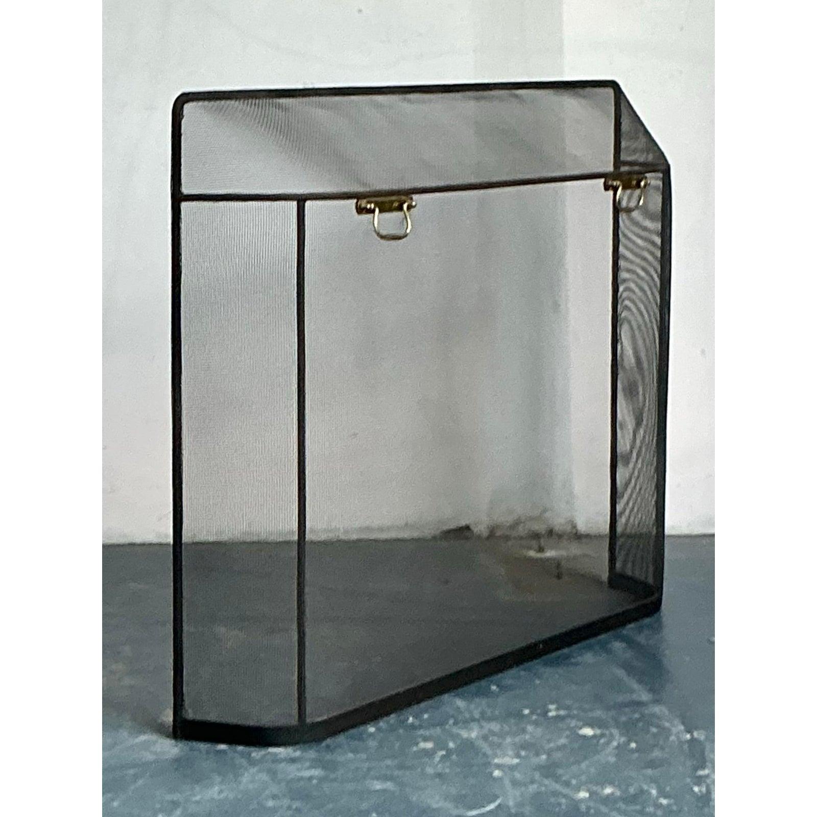 Questo paravento per caminetto vintage offre un approccio snello e minimalista agli accessori per il focolare, perfettamente adatto a interni contemporanei o di transizione. Il design è costituito da un unico pannello verticale formato da una rete