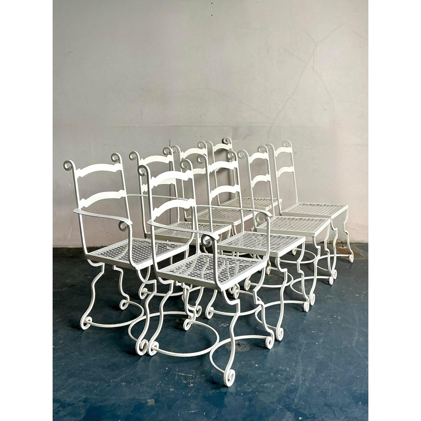 Questo squisito set di otto sedie da pranzo in ferro battuto cattura la sofisticata eleganza da esterni della Costa Azzurra e del classico stile Hollywood Regency. Caratterizzate da graziose strutture a voluta continua, schienali a scaletta