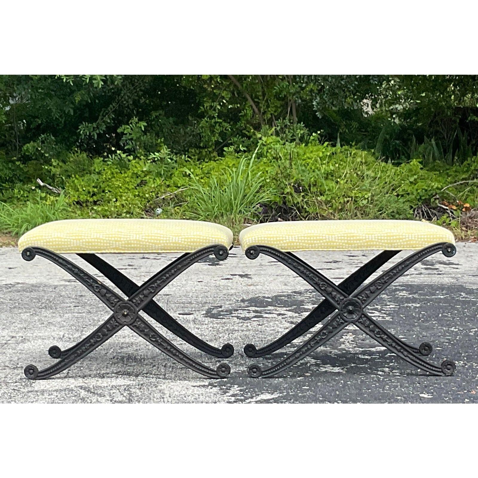 A fabulous pair of vintage Boho X benches. Beautiful detail on the wrought iron frame. Beautifully upholstered in a pale yellow with an embroidered dot. Acquired from a Palm Beach estate.