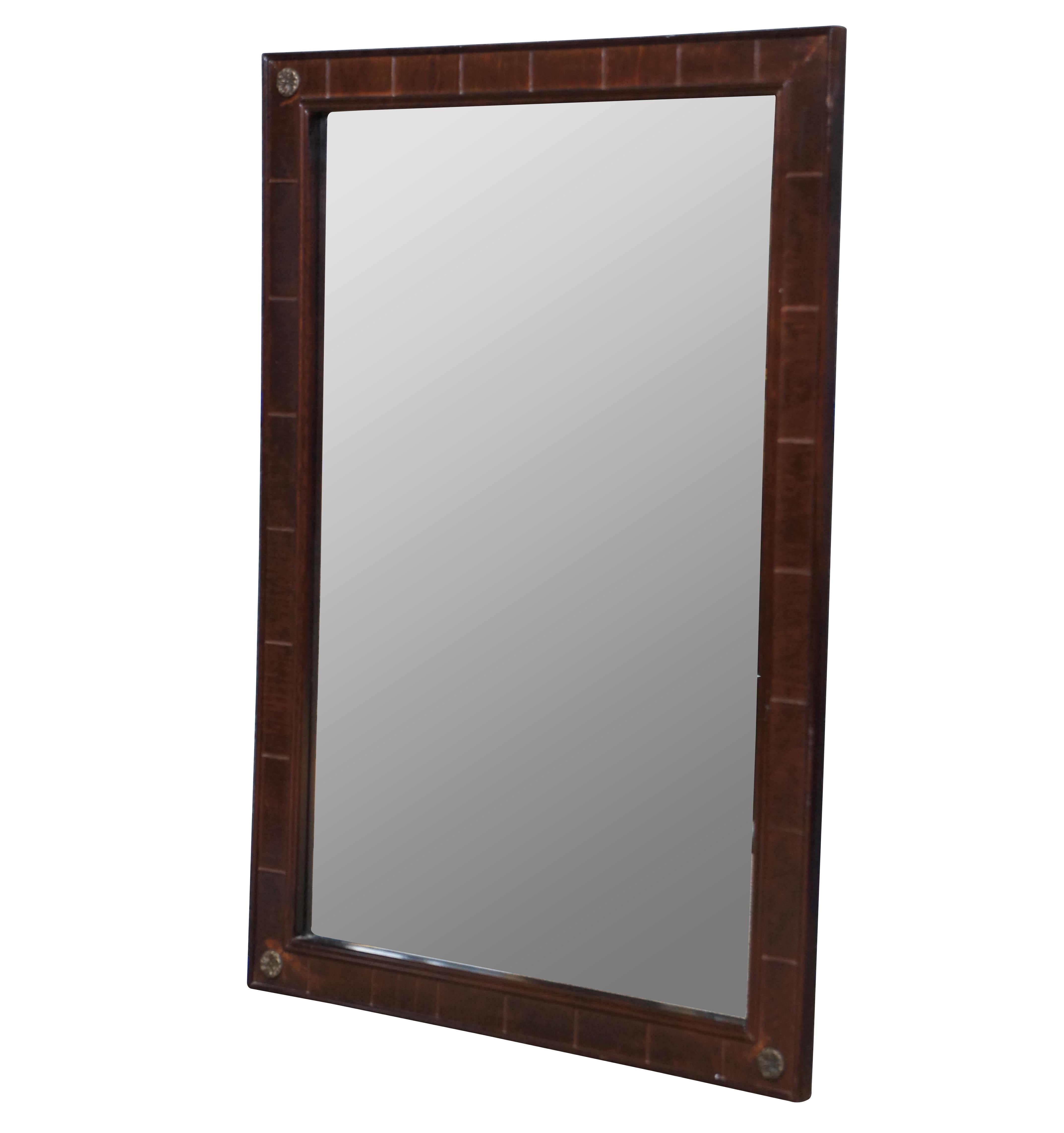 Late 20th century rectangular wall mirror by the Bombay Company, featuring paneled mahogany sides accented at the corners with small brass medallions.

21.75” x 0.75” x 32” / Sans Frame – 17.75” x 27.75” (Width x Depth x Height).