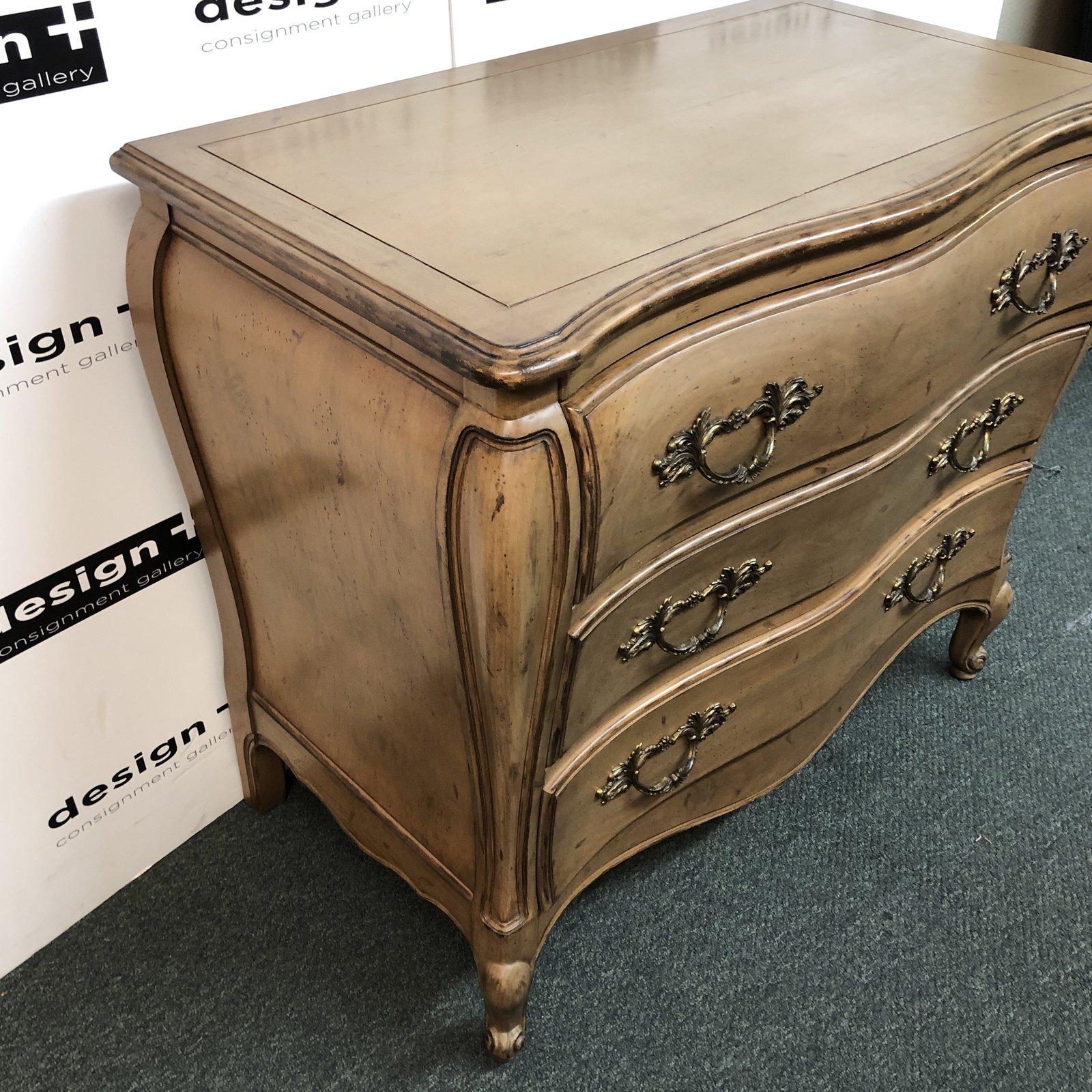 A vintage bombe chest, by Dixon-Powdermaker. Three divided drawers, there is roomy storage in this wonderful signed piece. The hardware is solid ornate brass, the feet delicately carved and the top front follows the curves and is shaped as well.