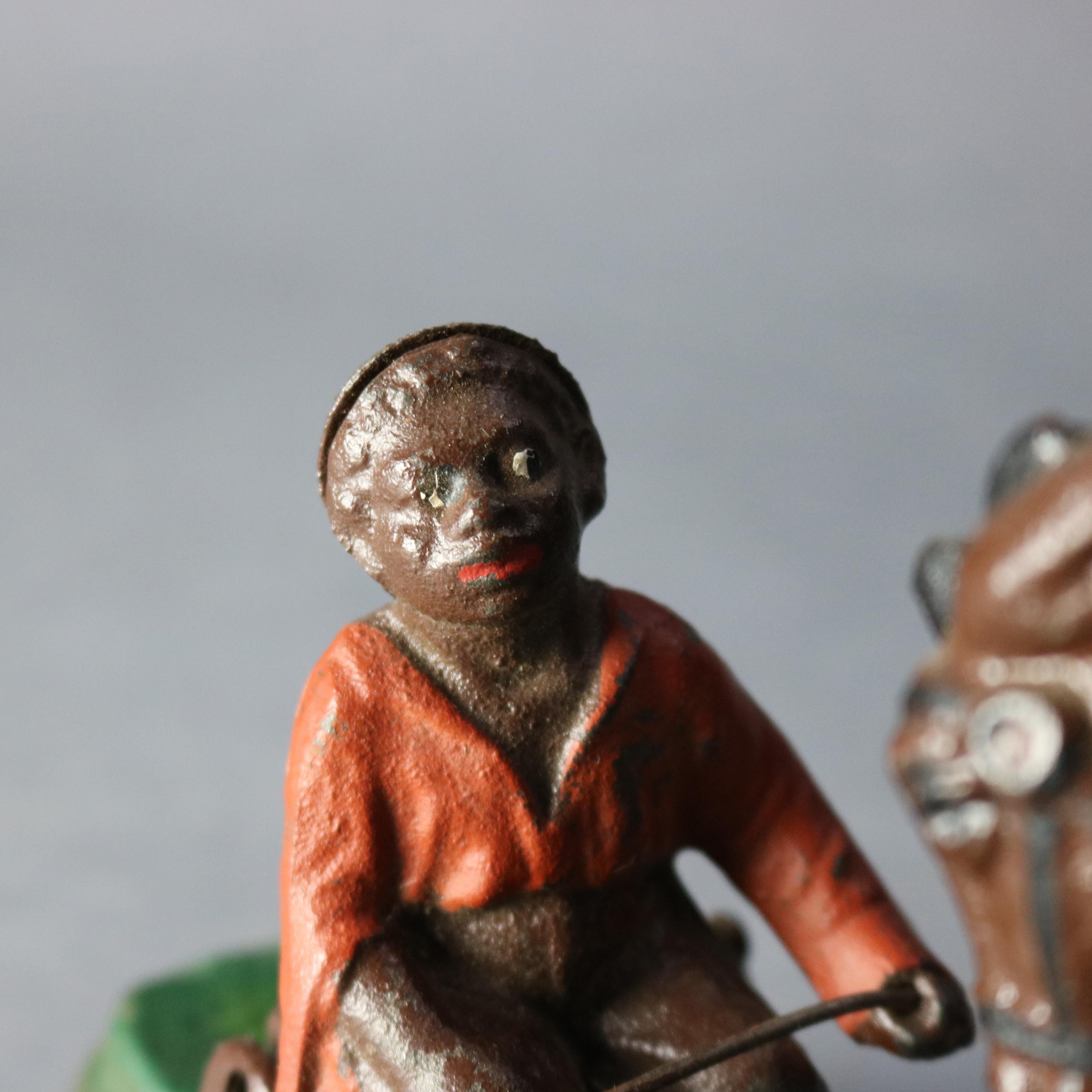 A vintage book of knowledge Spise a mule mechanical bank offers polychrome cast construction with boy and mule, underside reads 