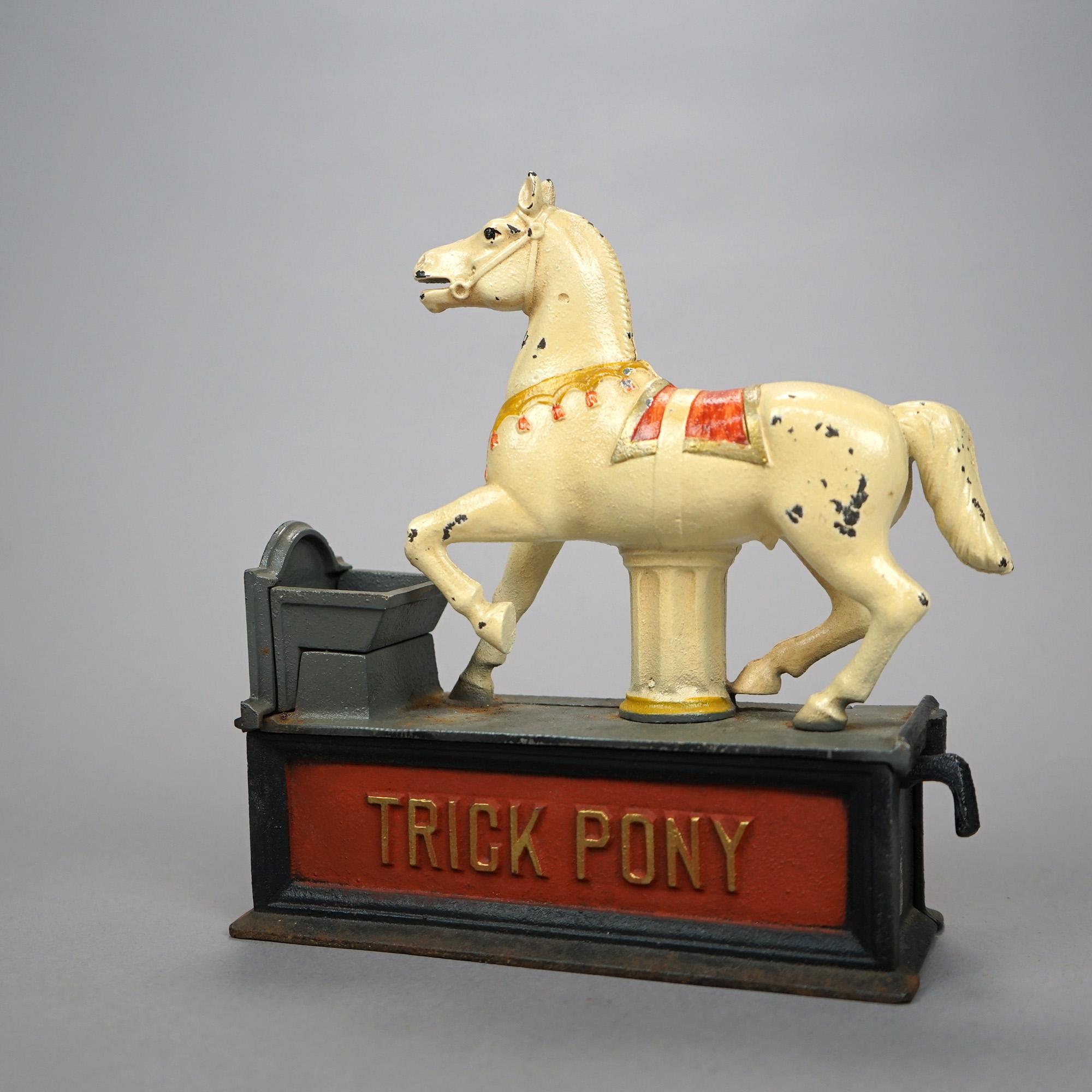 A vintage book of knowledge trick pony mechanical bank offers polychrome cast construction with white circus horse with embossed title, underside reads 