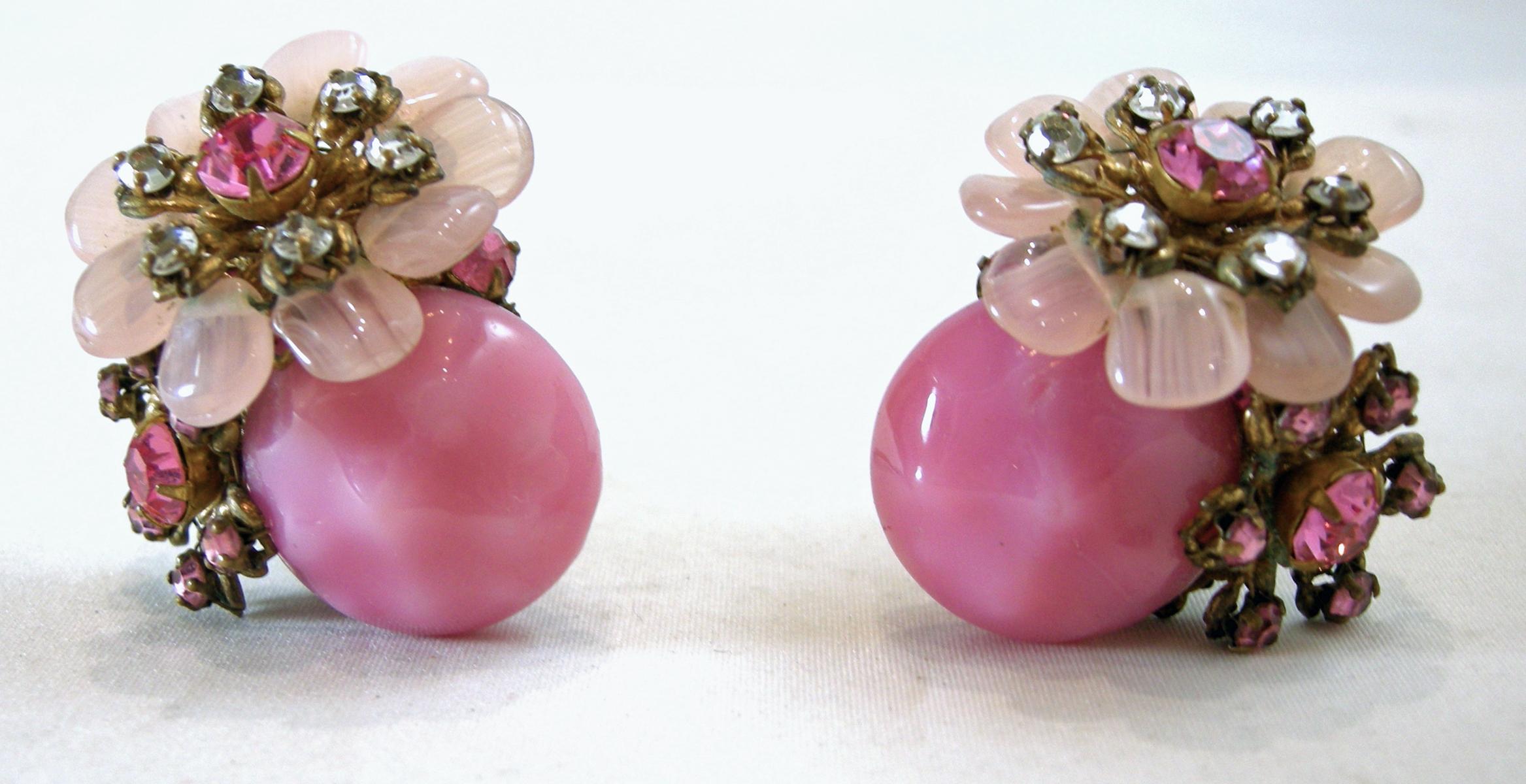 These vintage book piece signed Miriam Haskell earrings have a floral design with a large pink poured glass with pink and clear crystals flowers on top … in a gold tone setting.  These clip earrings measure 1-1/4” x 1-1/4” and are signed “Miriam