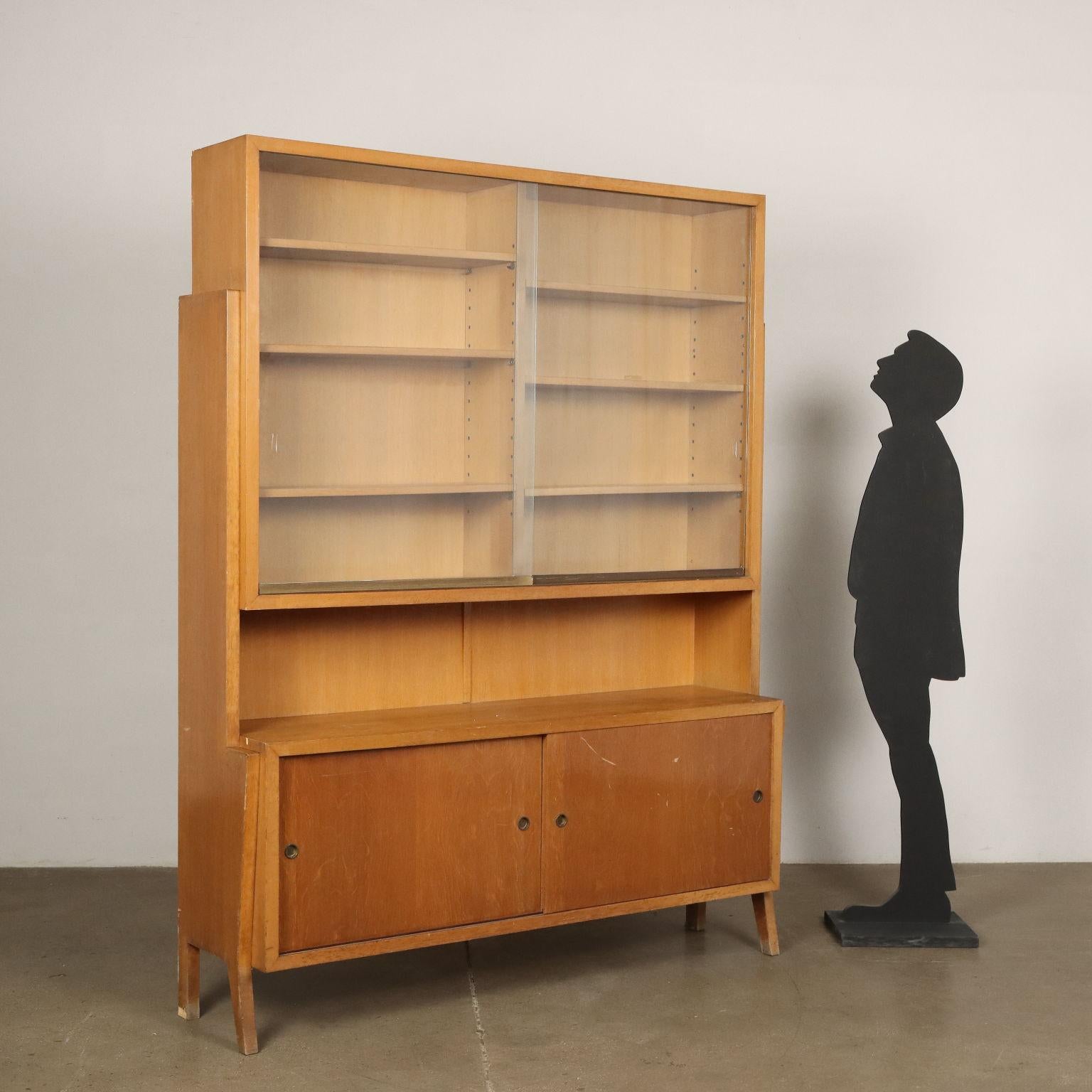 Bookcase unit with sliding glass doors and storage compartment with sliding doors in oak veneered wood.