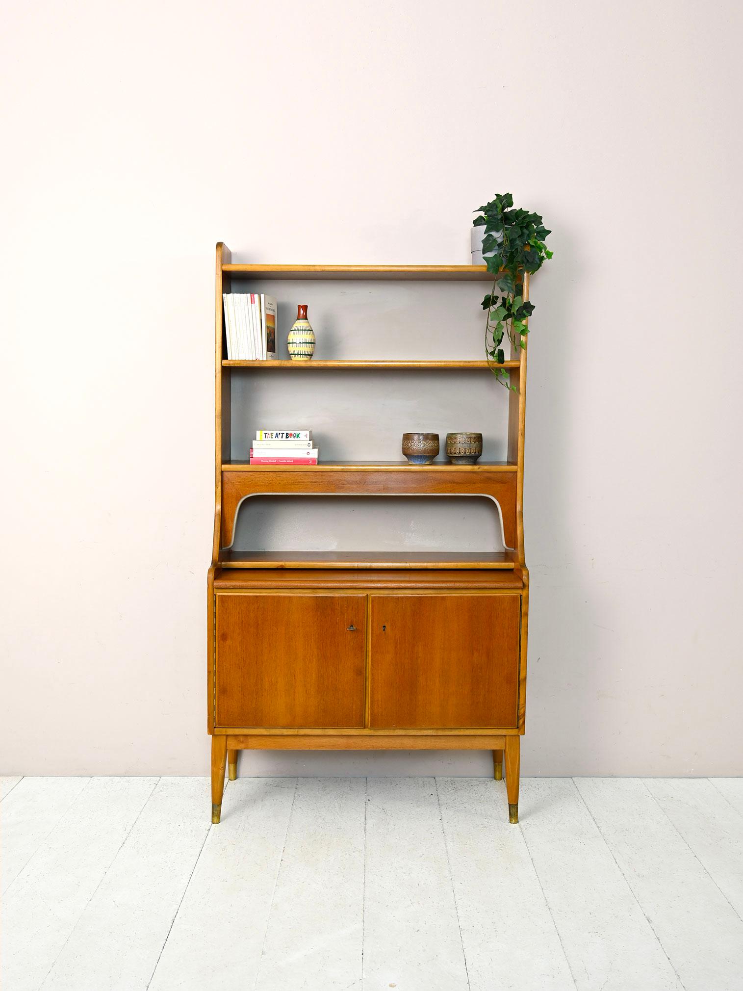 Particular original Swedish bookcase cabinet from the 1960s.

The structure consists of a cabinet with lockable hinged doors inside which are two small drawers and a shelf; the top can be pulled out if necessary become a convenient desk. The upper