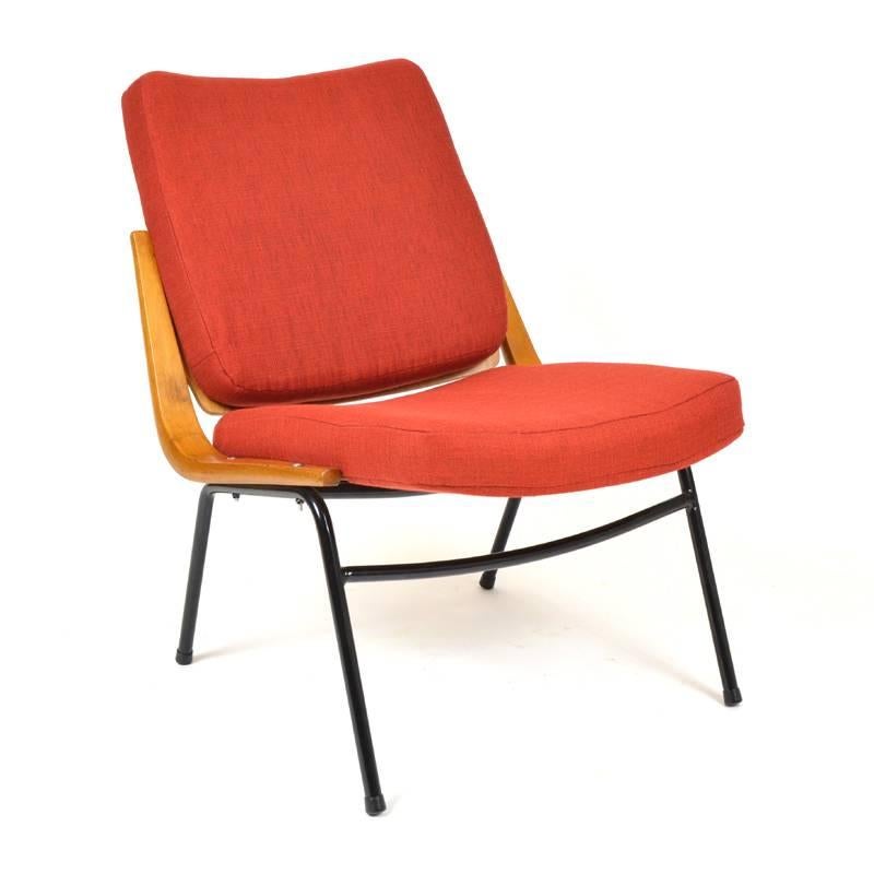 This armchair was made by TON in the 1960s in style of boomerang chairs. It is very rare model, which was manufactured not in many pieces. It features a black metal base and a newly upholstered seat in red. Second armchair in green-yellow upholstery