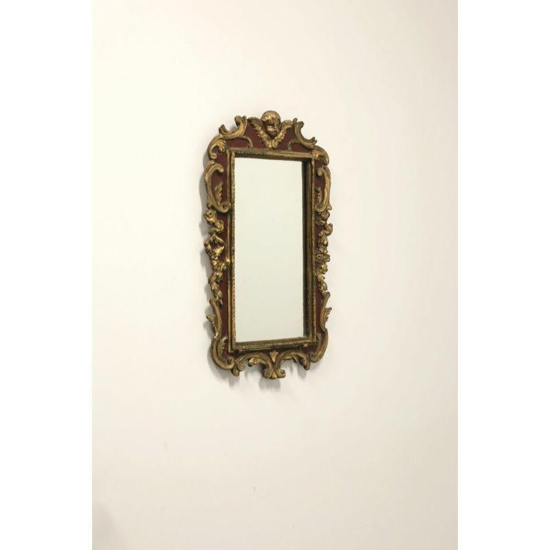 A vintage Italian style wall mirror by Borghese. Mirrored glass, gold gilt and maroon painted cast plaster on wood frame. Decoratively adorned frame with cherub at top. Made in Italy, in the early 20th Century.

Measures: 16 W 1.5 D 26.5 H, Weighs