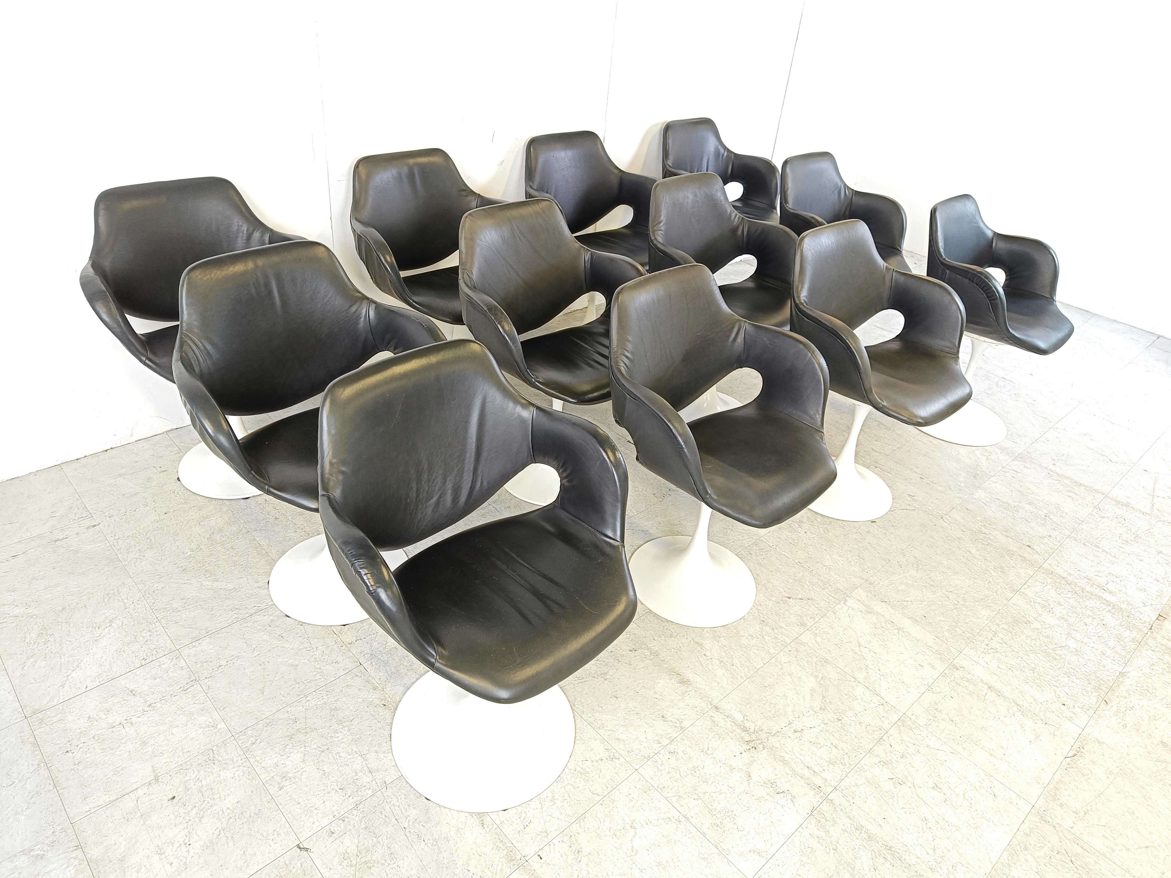 Rare set of 12 tulip base dining chairs by Boris Tabacoff.

These elegant chairs feature black skai upholstery and have a white lacquered metal tulip shaped base.

The white lacquered metal bases have some light age related wear.

Beautiful design,