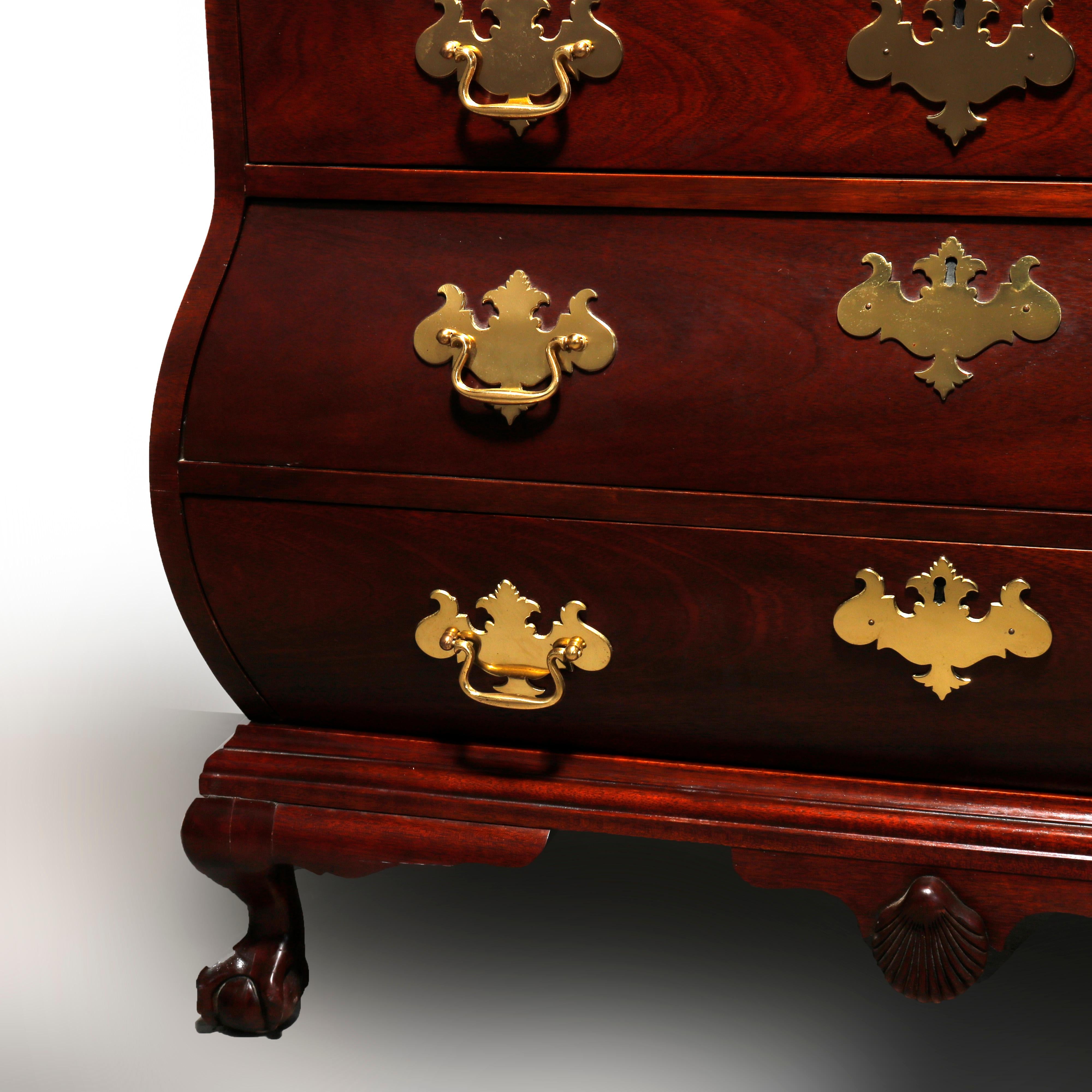 A vintage Boston Chippendale style bombe style chest of drawers or silver chest by Baker offers mahogany construction with beveled top surmounting swell form case having four drawers and raised on cabriole legs terminating in claw and ball feet,