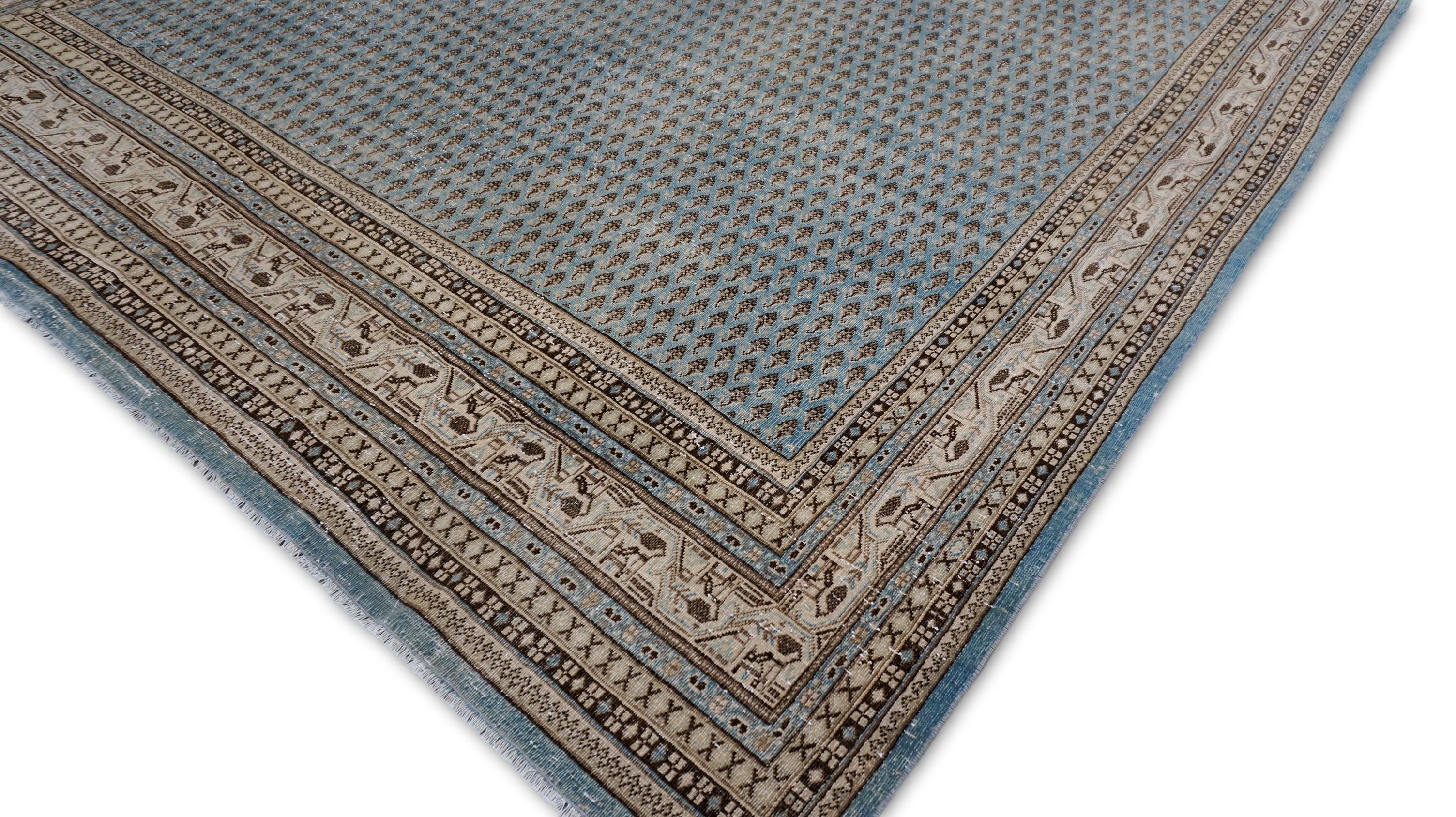 Esta alfombra de lana anudada a mano ejemplifica una artesanía meticulosa y un arte refinado con una rica herencia arraigada en las tradiciones textiles. La pieza central de esta llamativa pieza presenta un apretado motivo boteh repetido, que
