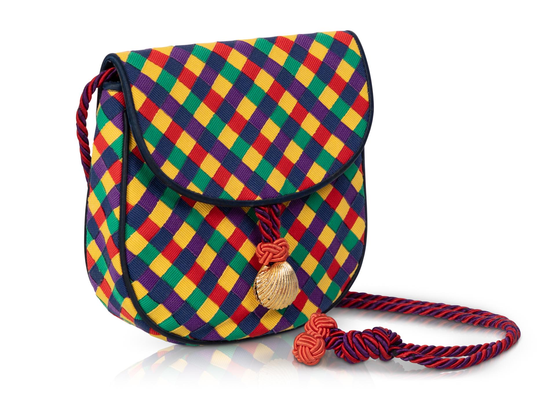 Known for producing high-quality leather goods, this bag is a departure from the Bottega Veneta traditional style. Maintaining the brand’s iconic weave, this purse is crafted entirely of grosgrain ribbons of red, navy, green, yellow, and purple that