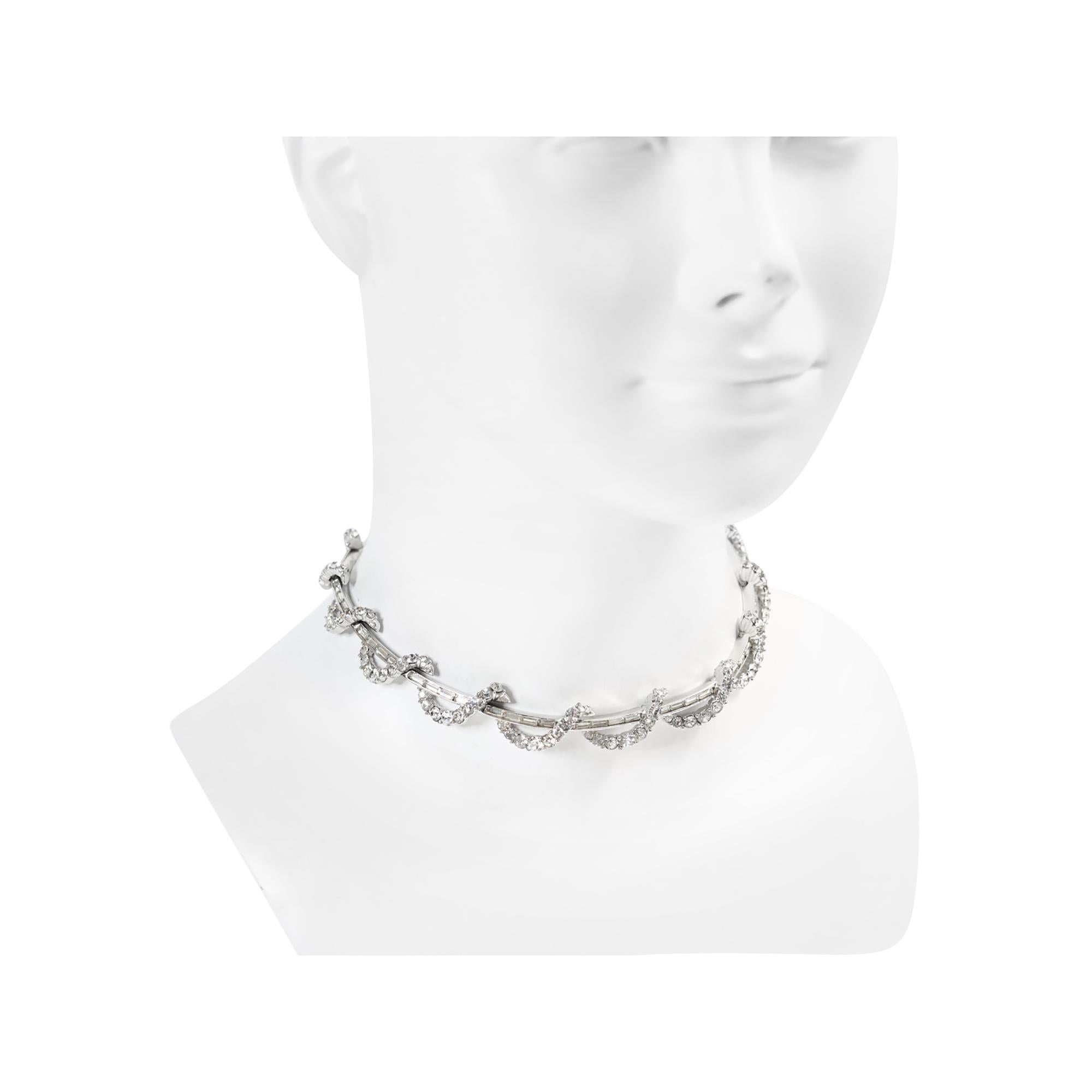 Vintage Boucher Baguette and Round Necklace Circa 1960s. This necklace looks fine.  It is a rigid necklace in sections, featuring baguettes with a piece that appears to wrap around continually, composed of rounds all prong-set.

Boucher originally