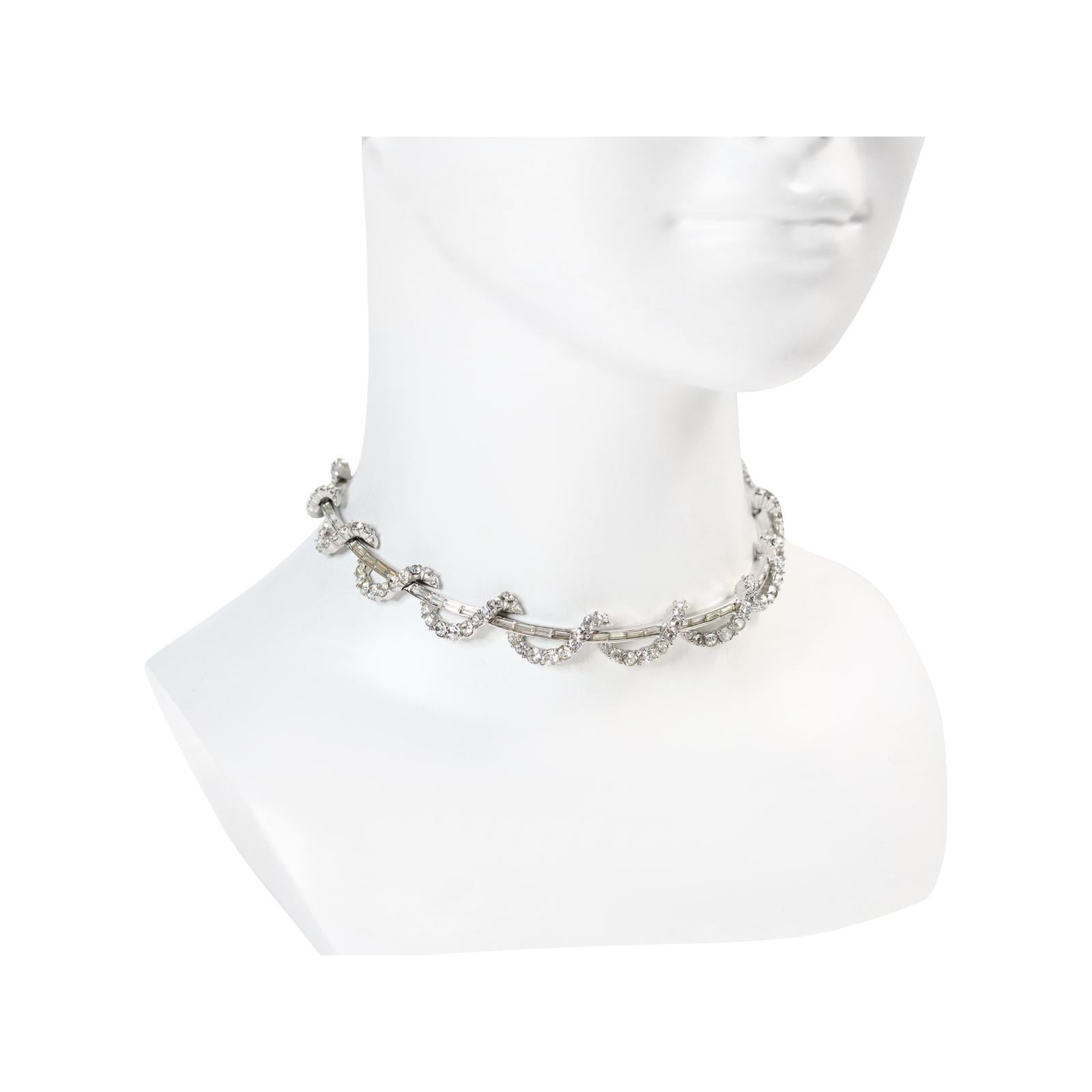 Collana vintage Boucher Baguette e Round Circa 1960. Questa collana è bella.  Si tratta di una collana rigida a sezioni, con baguette e un pezzo che sembra avvolgersi continuamente, composto da tondi tutti incastonati.

Boucher è arrivato da Parigi