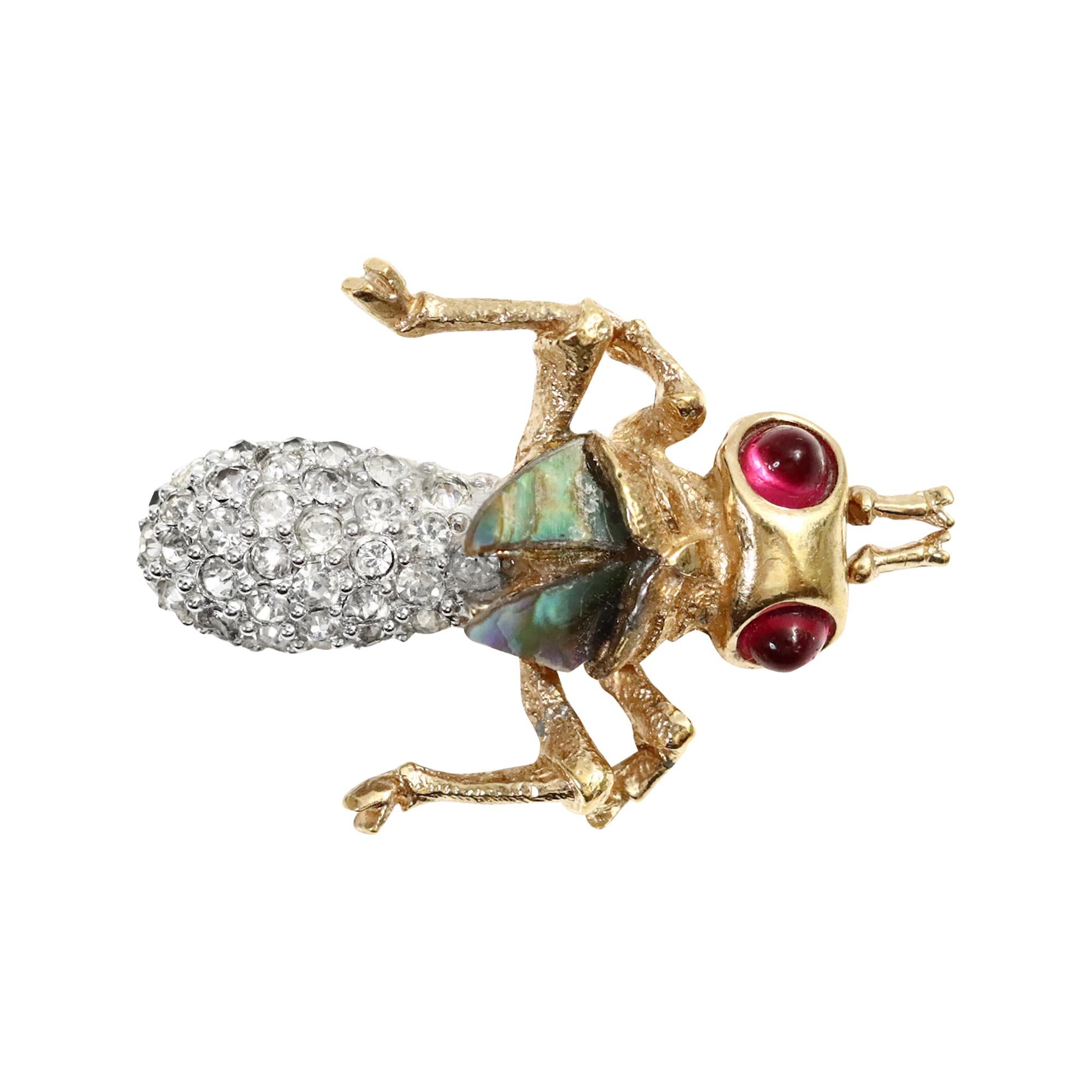 Broche Vintage Boucher Circa 1960. Les photos ne rendent pas justice à ce produit.  Le corps est pavé et les ailes semblent être en nacre irisée verte. Les yeux sont sertis de cristaux rouges en or. Il est petit mais tellement magnifique.  C'est
