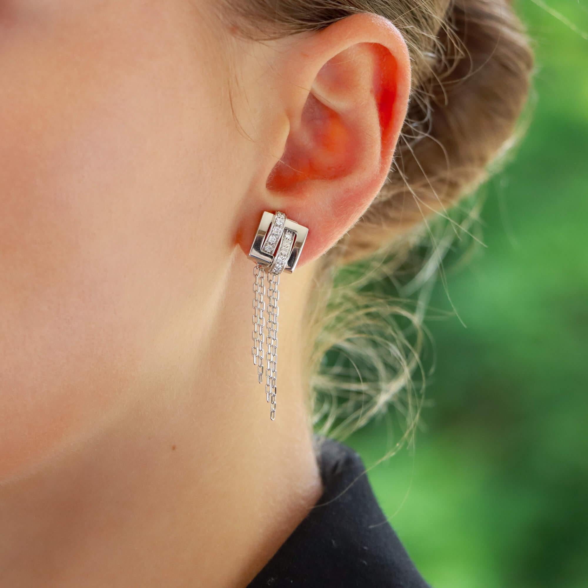  A beautiful pair of vintage Boucheron 'Dechainee' diamond drop earrings set in 18k white gold.

From the now discontinued 'Dechainee' collection, each earring is firstly composed of a geometric squared design. The design is set with a sequence of