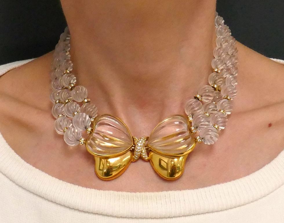 Stunning three-strand necklace with a bow in the center made of carved rock crystal, diamonds and 18k yellow gold.
The vintage French necklace measures 14 ½” x 1 ½”. The carved rock crystal balls are graduating from approximately ½” to ¼” in