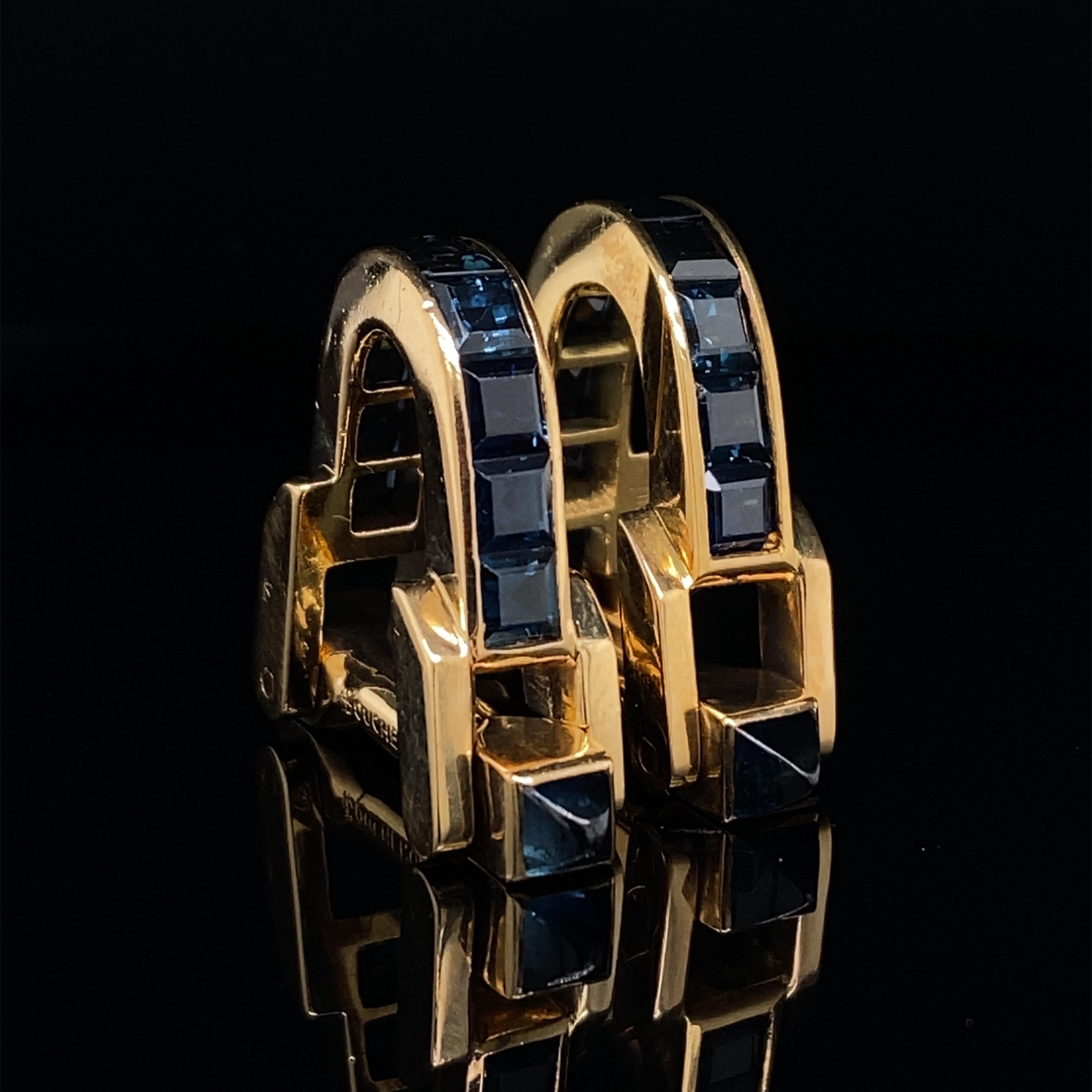 A vintage pair of Boucheron sapphire stirrup cufflinks in 18 karat yellow gold, circa 1950.
 
This is a superb set of cufflinks, channel set along their length with bright, lively calibré cut sapphires and functioning with a click-shut-fitting.