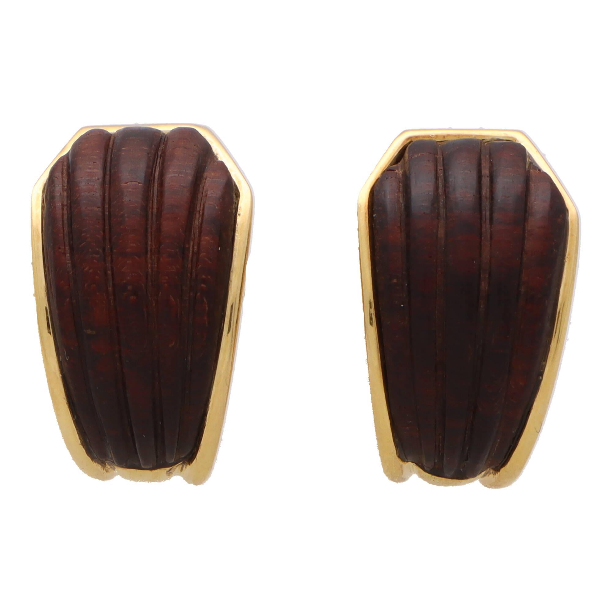 An extremely rare and beautiful pair of Boucheron wood clip on half hooped earrings set in 18k yellow gold.

The pair are each set with a carved piece of wood which have each been individually carved into a shell like motif. Each piece is then