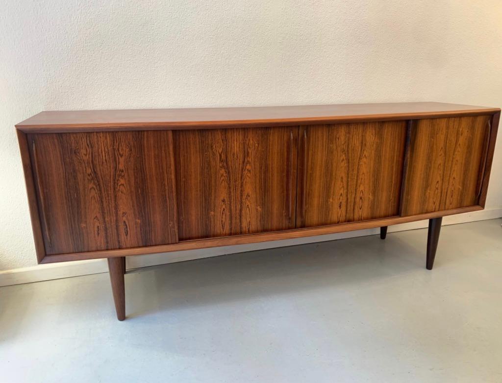 Elegant Rio rosewood bow front sideboard by Arne Vodder produced by H.P. Hansen Denmark ca. 1960
4 sliding doors, 4 drawers inside on the left side, double door cabinet in the middle and a single door cabinet on the right.
Measures: L 200 x D 52 x
