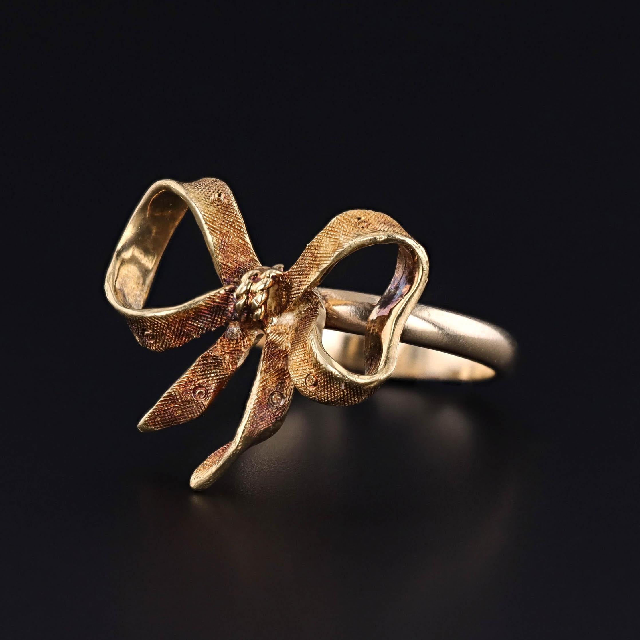 A ring featuring a bow of 18k gold, created from a vintage brooch (circa 1930-1945) and a 14k gold band.

The bow measures 0.8 inches by 0.85 inches wide and is in great condition. it is a size 6.5 but can be resized for an additional charge.

The