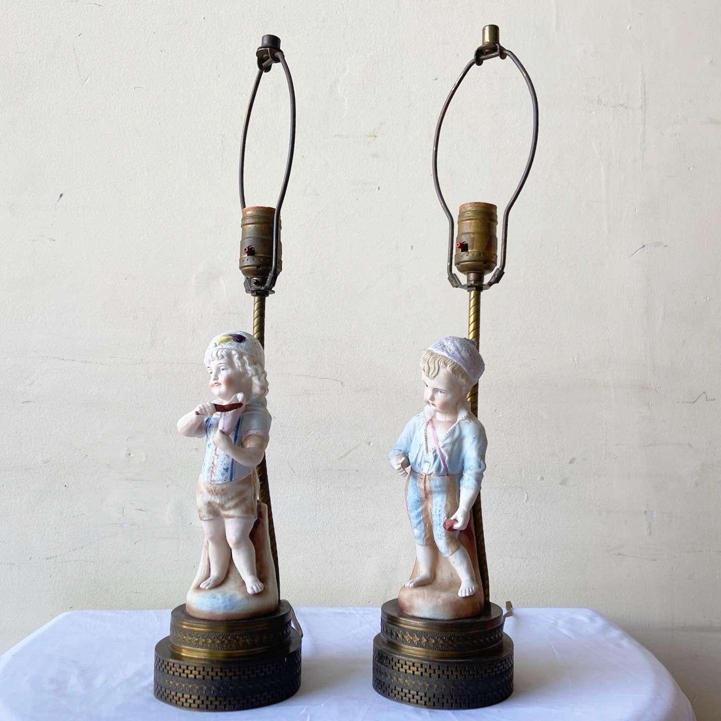 Außergewöhnliches Paar von Vintage-Keramik-Tischlampen. Jede Lampe zeigt einen Jungen und ein Mädchen mit einem Messingfuß.
