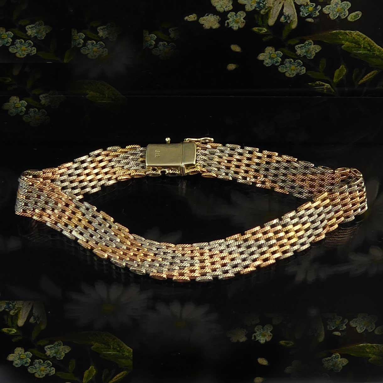 A vintage gold bracelet from small, oval gold links in white gold and rose gold with all links having a diagonal pattern to the front.  The two coloured golds have been connected in such a way as to produce a chevron pattern along the length of the